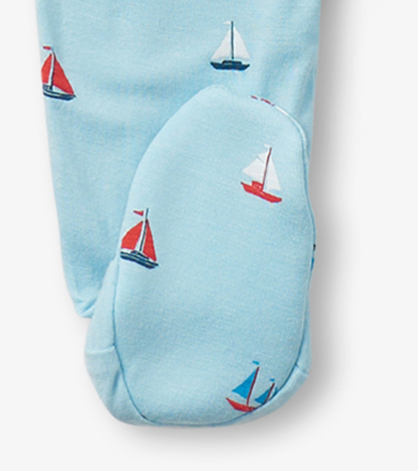 Light blue footed sleeper featuring tiny red and white sailboat patterns, designed for baby boys.