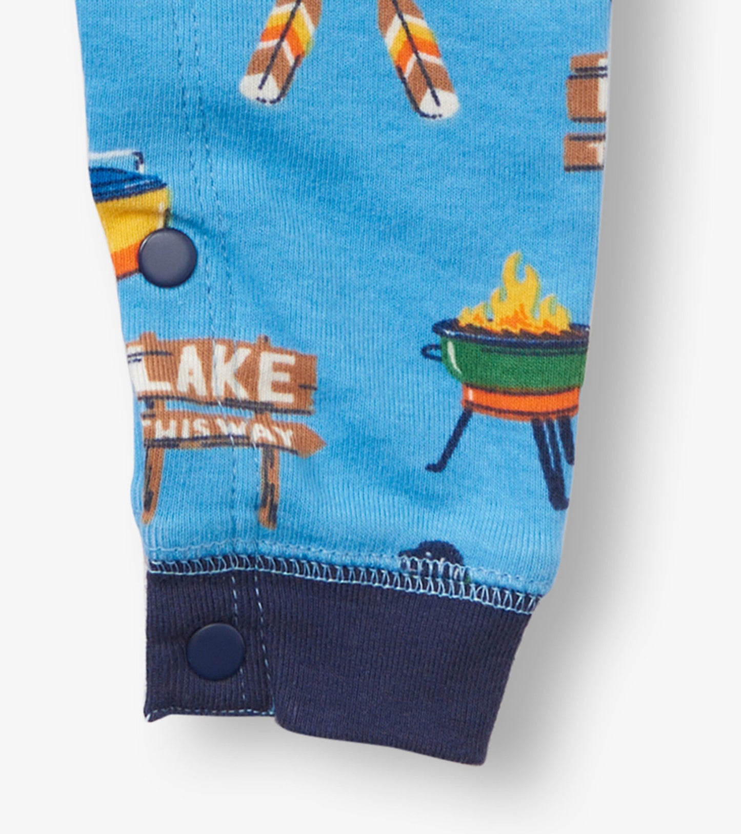 Blue baby sleeper featuring a playful lake-themed print with campfire and sign graphics, finished with navy cuffs.