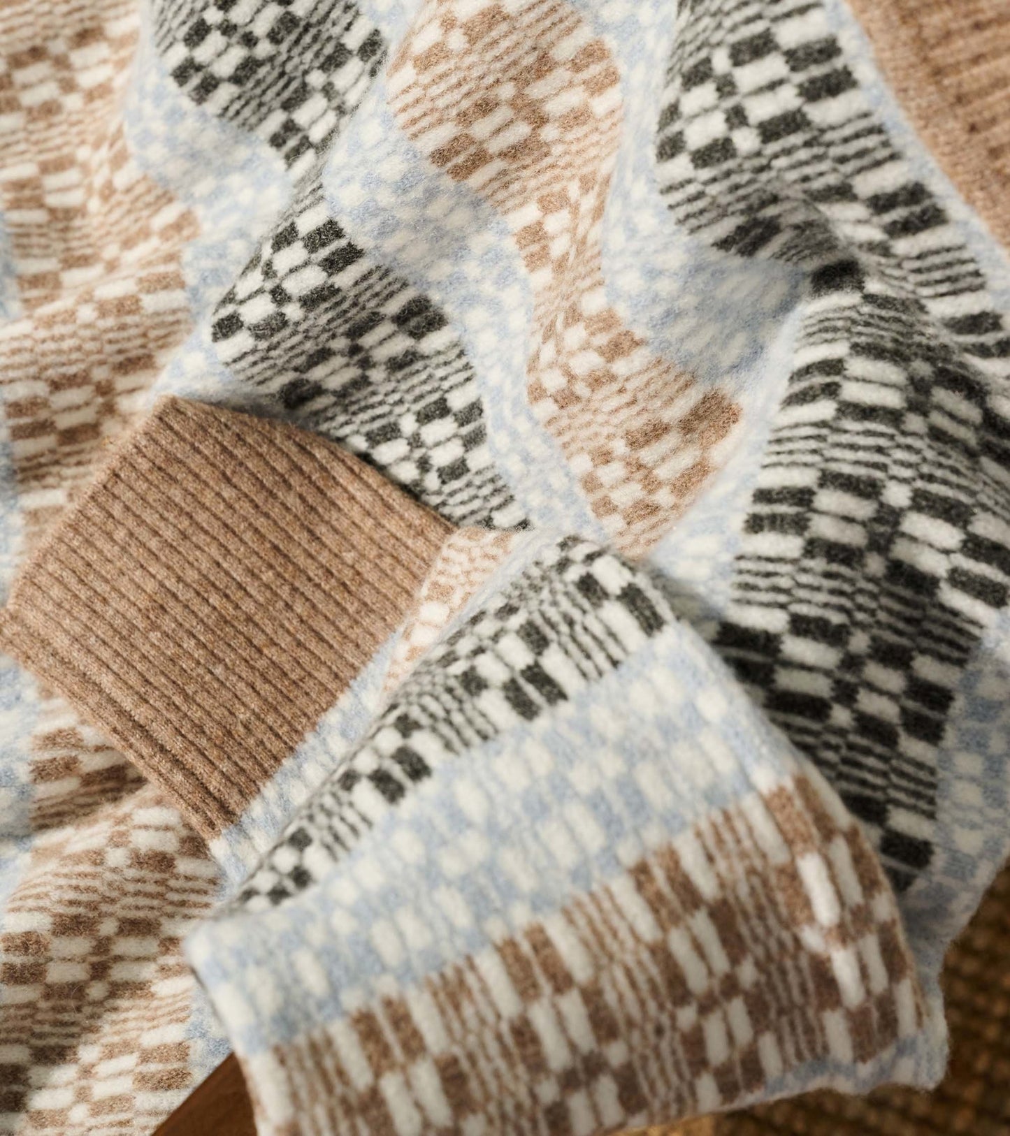 Mock neck sweater featuring a celestial plaid pattern in soft browns, blues, and blacks, with ribbed cuffs.