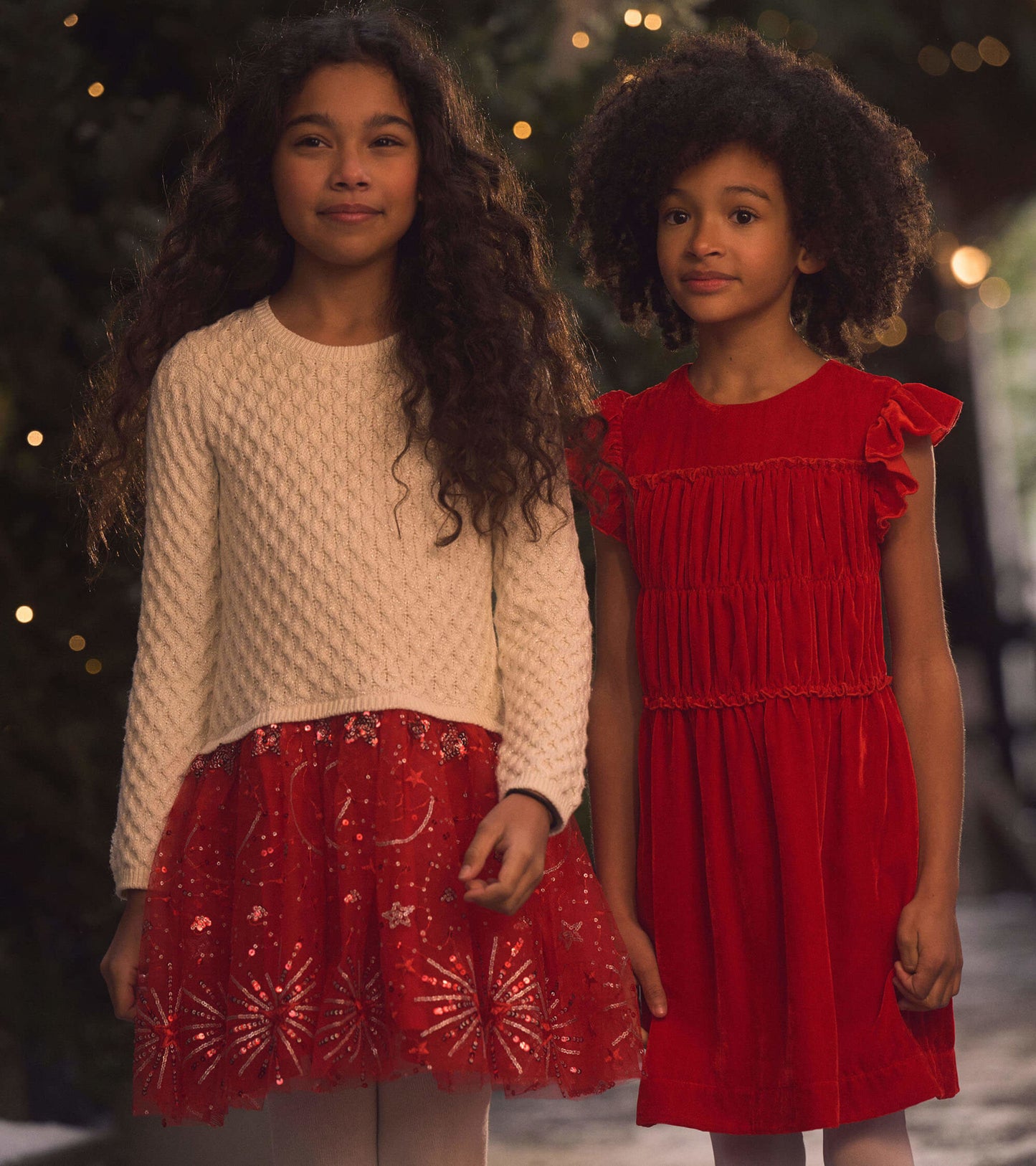 Red velvet dress with smocked panel and ruffled sleeves, perfect for festive occasions.