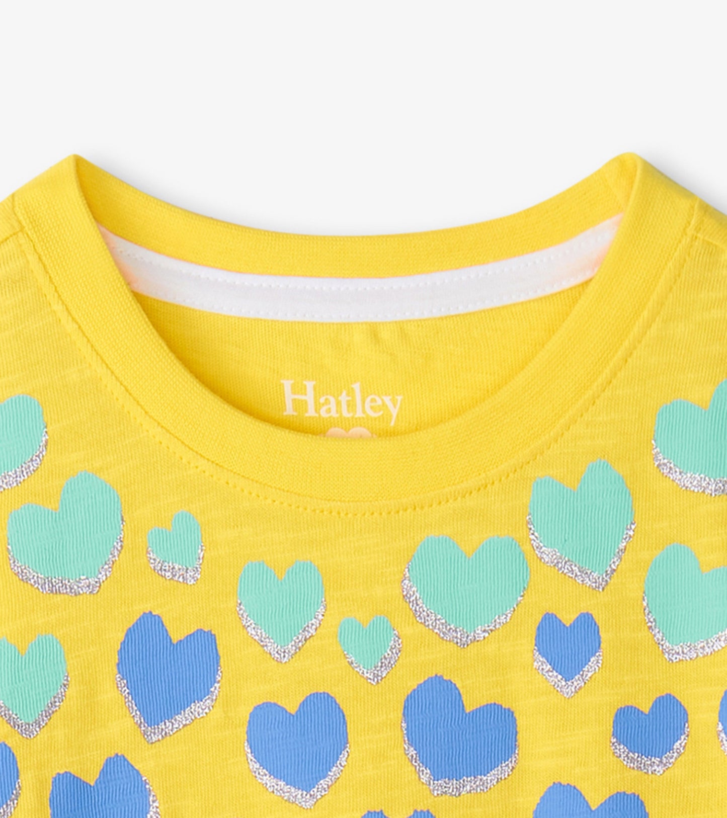Yellow graphic tee featuring various hearts in blue and green with glitter accents, showcasing a round neckline.