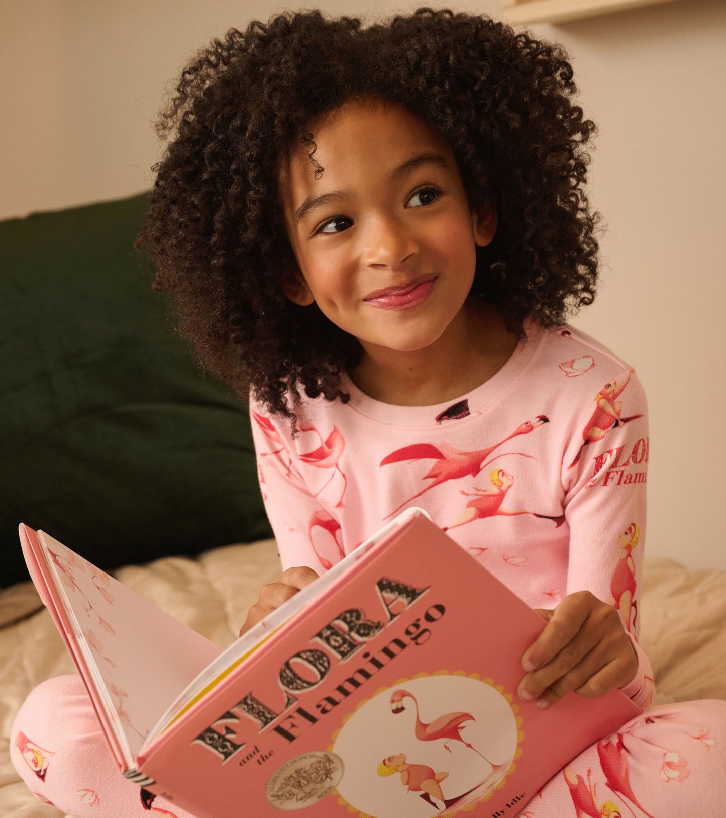 Pink pajama set with flamingo pattern, paired with a children's book featuring the same theme.