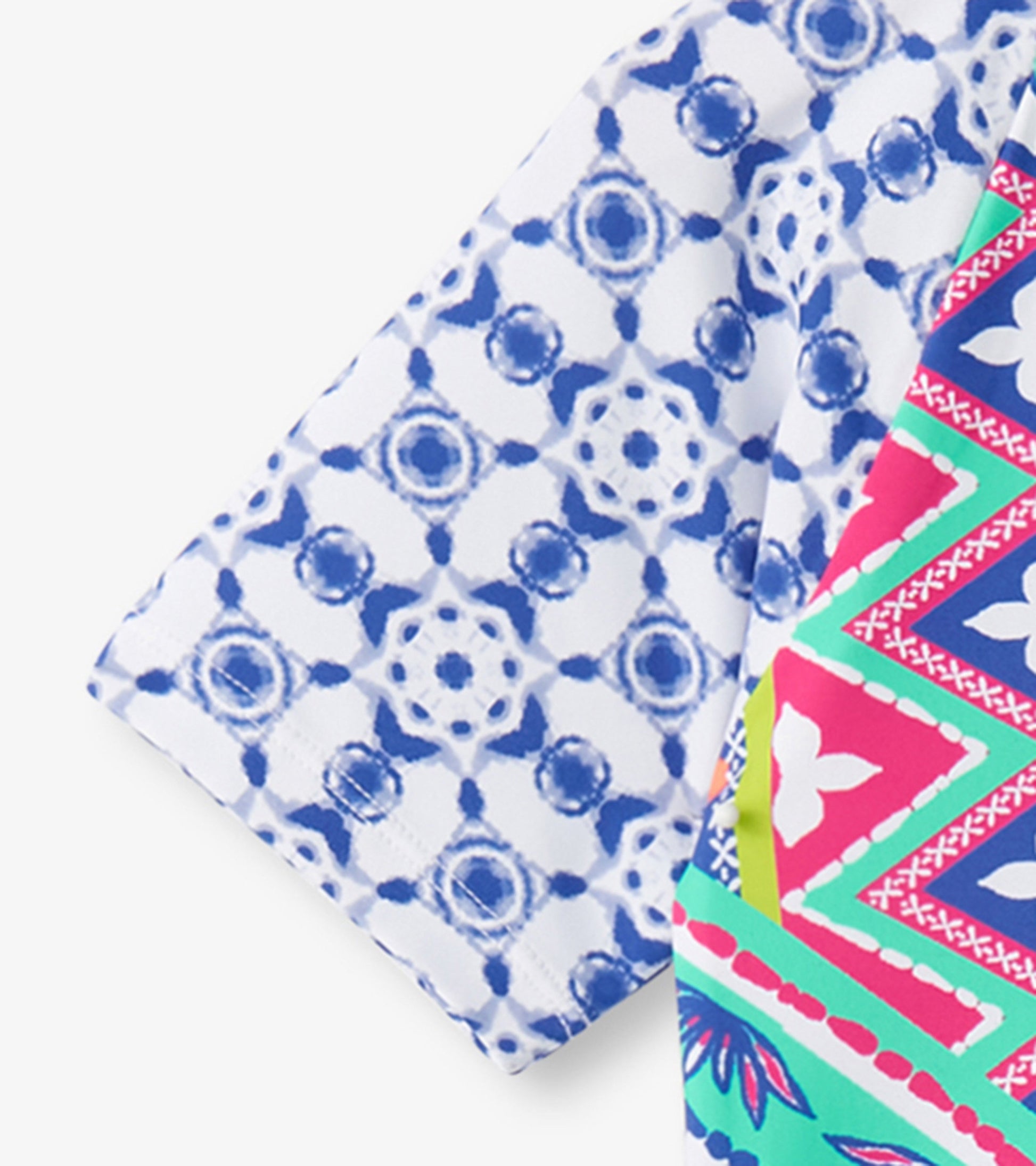 Colorful one-piece rashguard featuring a blue and white kaleidoscope pattern with vibrant pink and green accents.