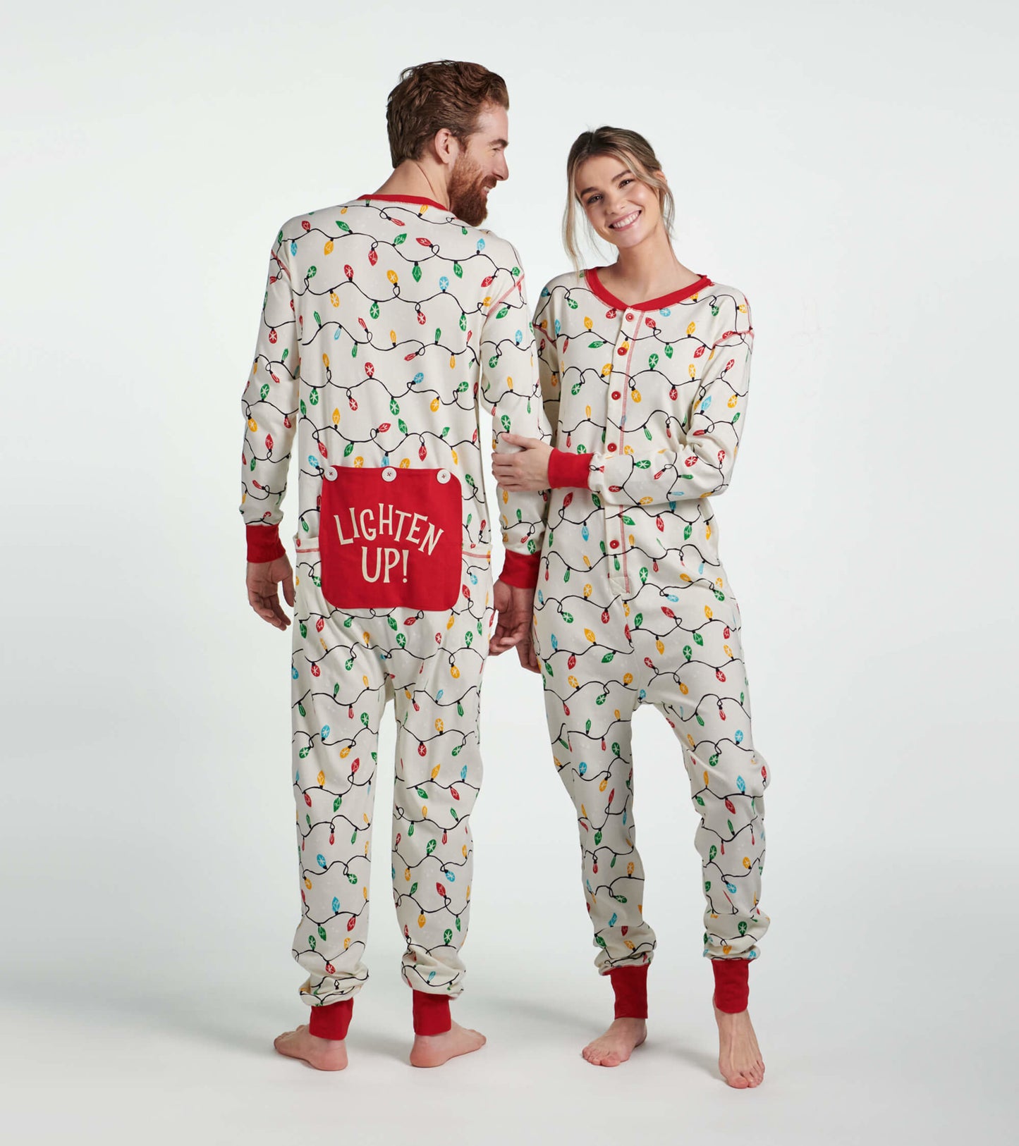 Adult onesie featuring a festive light bulb pattern, red accents, and a "LIGHTEN UP!" pocket on the back.