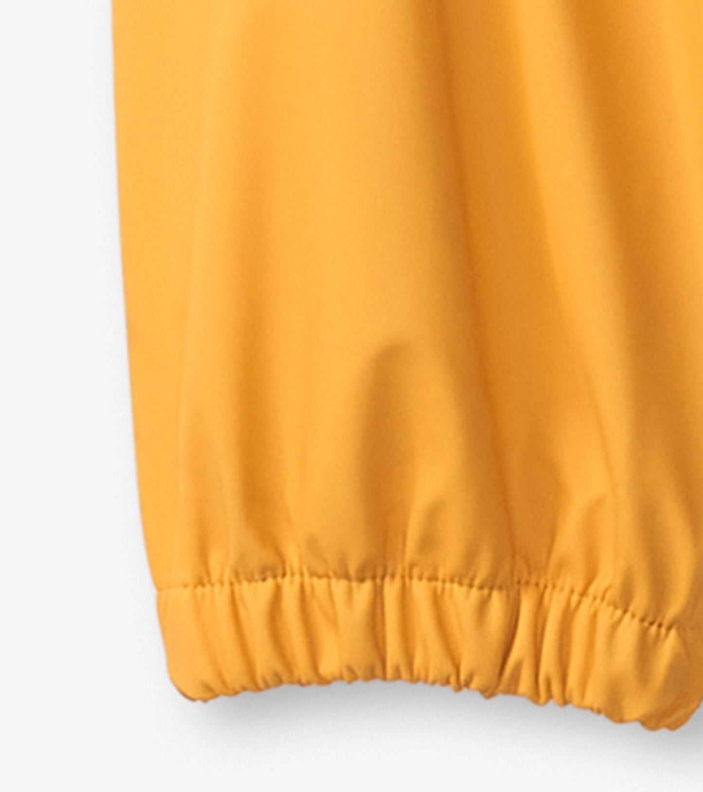 Yellow waterproof kids' rain pants with elastic cuffs, designed for outdoor play in wet weather.