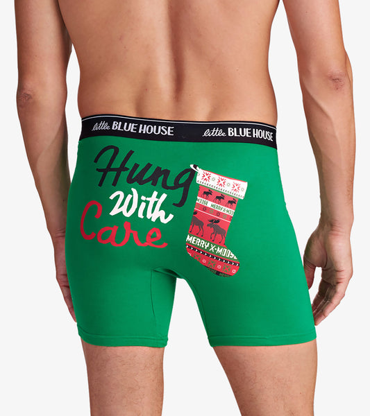 Green boxers featuring a festive design with "Hung With Care" and a Christmas stocking graphic on the back.