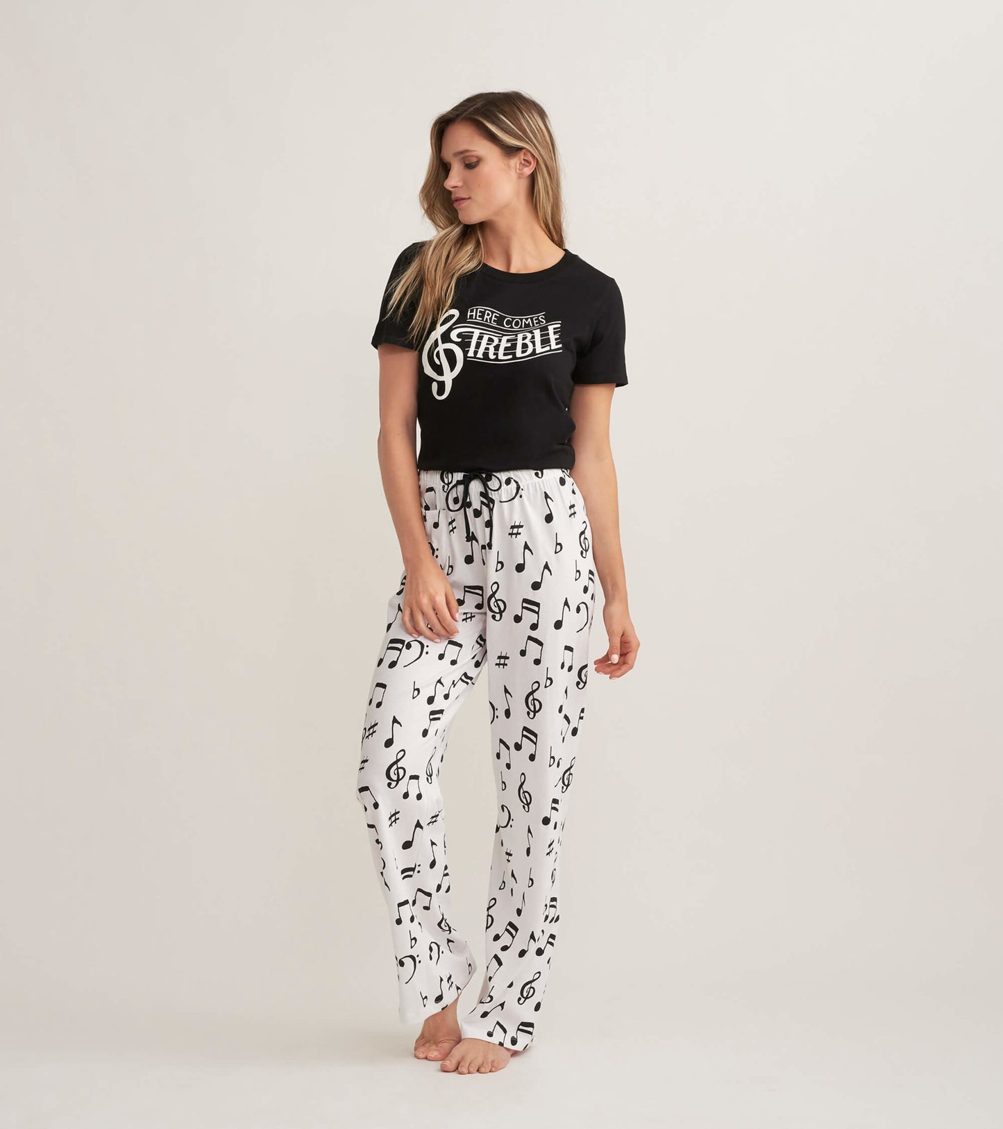 White cotton pajama pants with black musical notes, featuring an elastic waistband and a relaxed fit.