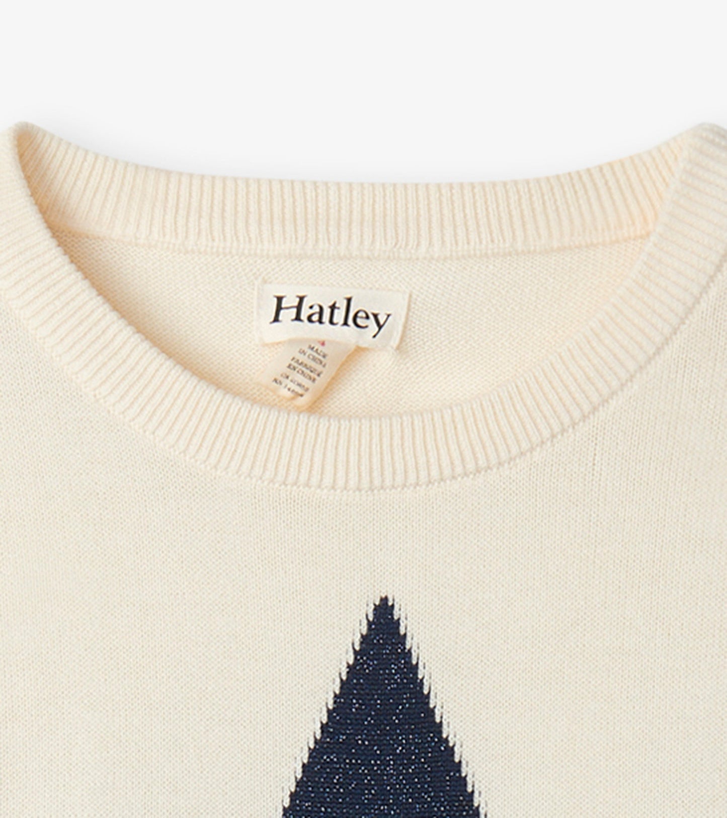 Cream sweater featuring a navy shooting star design, with a ribbed crew neckline and soft knit material.