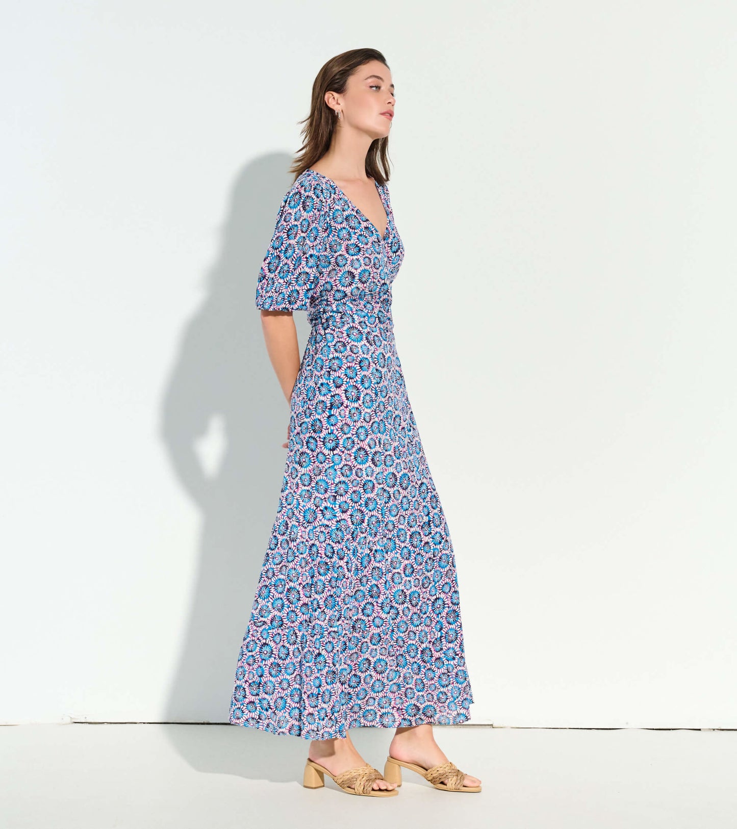 Maxi dress featuring a sundial mandala pattern in blue and pink, with a v-neckline and short puff sleeves.