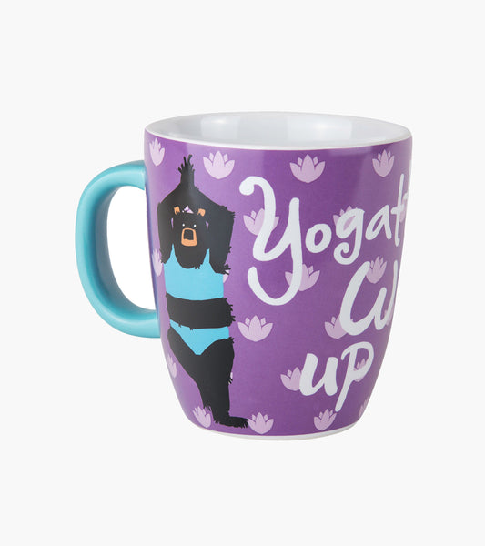 Curved ceramic mug with a purple background, featuring a yoga-themed design and a turquoise handle.