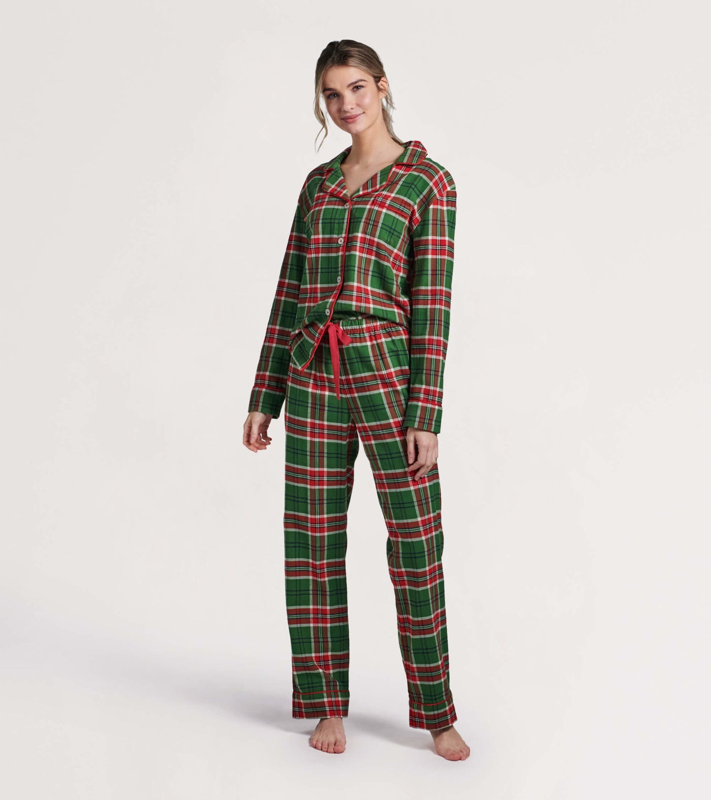 Green and red plaid flannel pajama set with long sleeves and pants, featuring a button-up top and a tied waistband.
