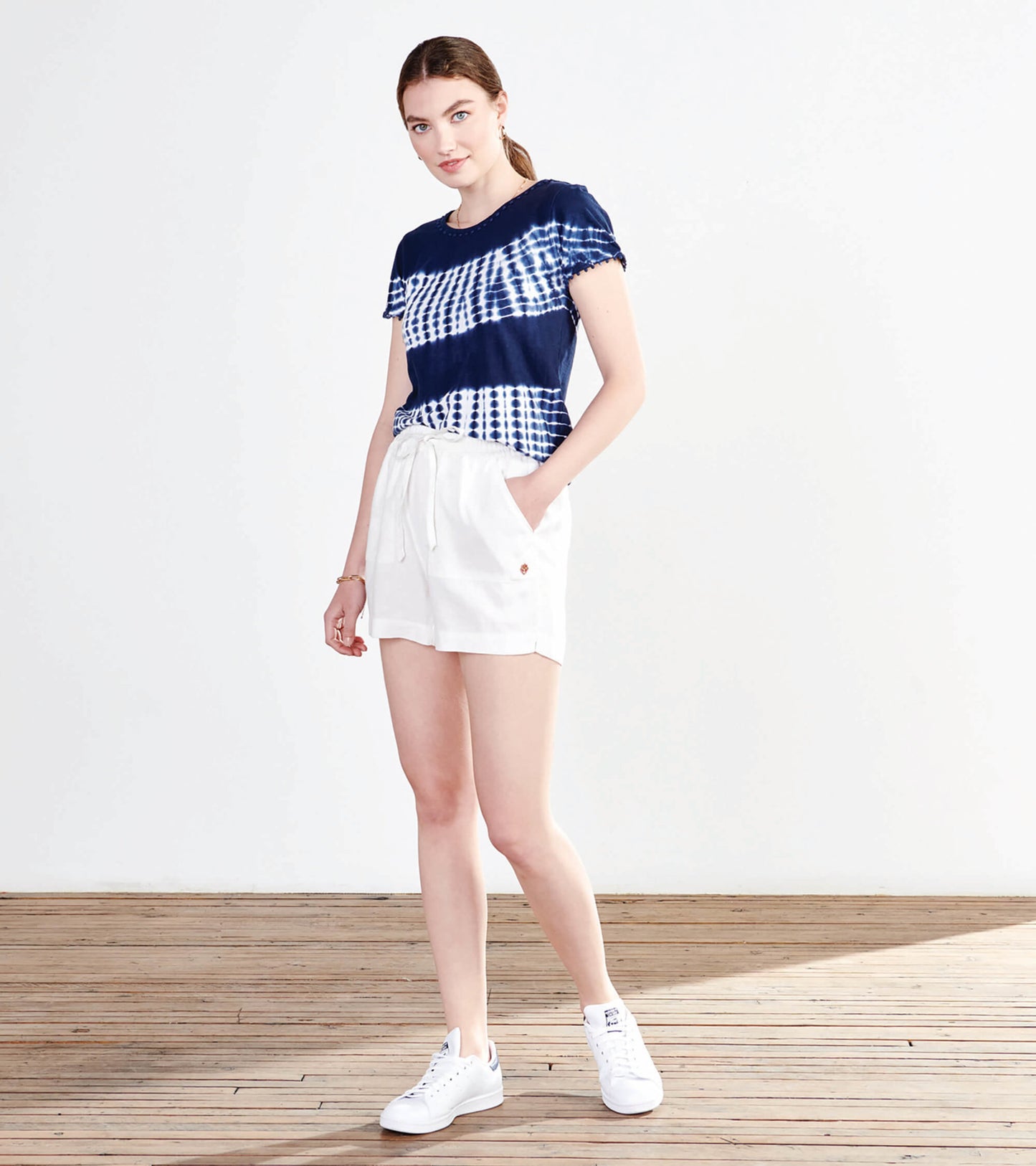 Navy blue tie-dye tee with short sleeves, paired with white shorts, styled casually for a relaxed look.