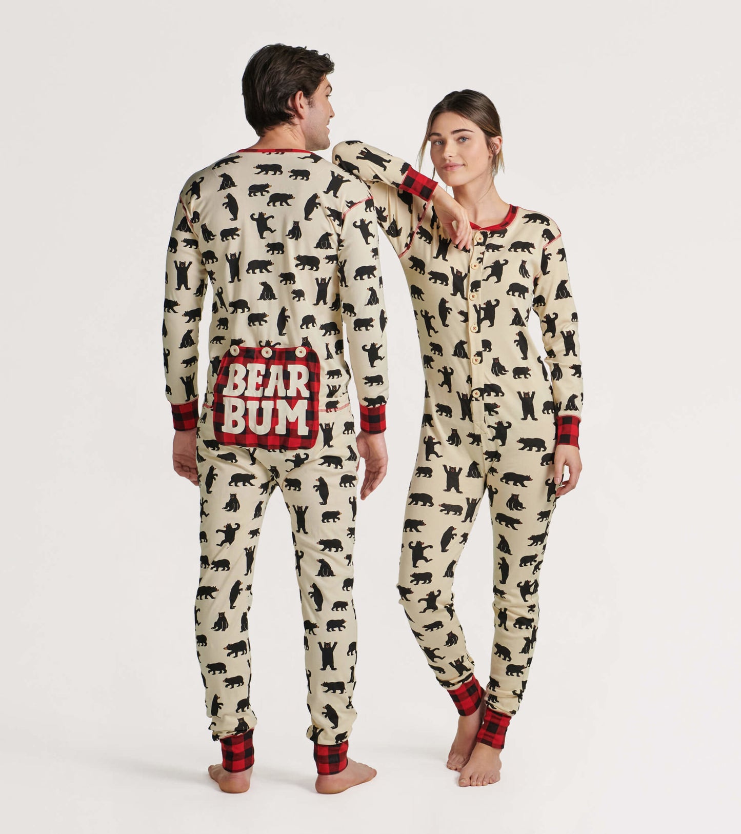Cream-colored adult onesie with black bear prints and red plaid accents, featuring a "BEAR BUM" design on the back.