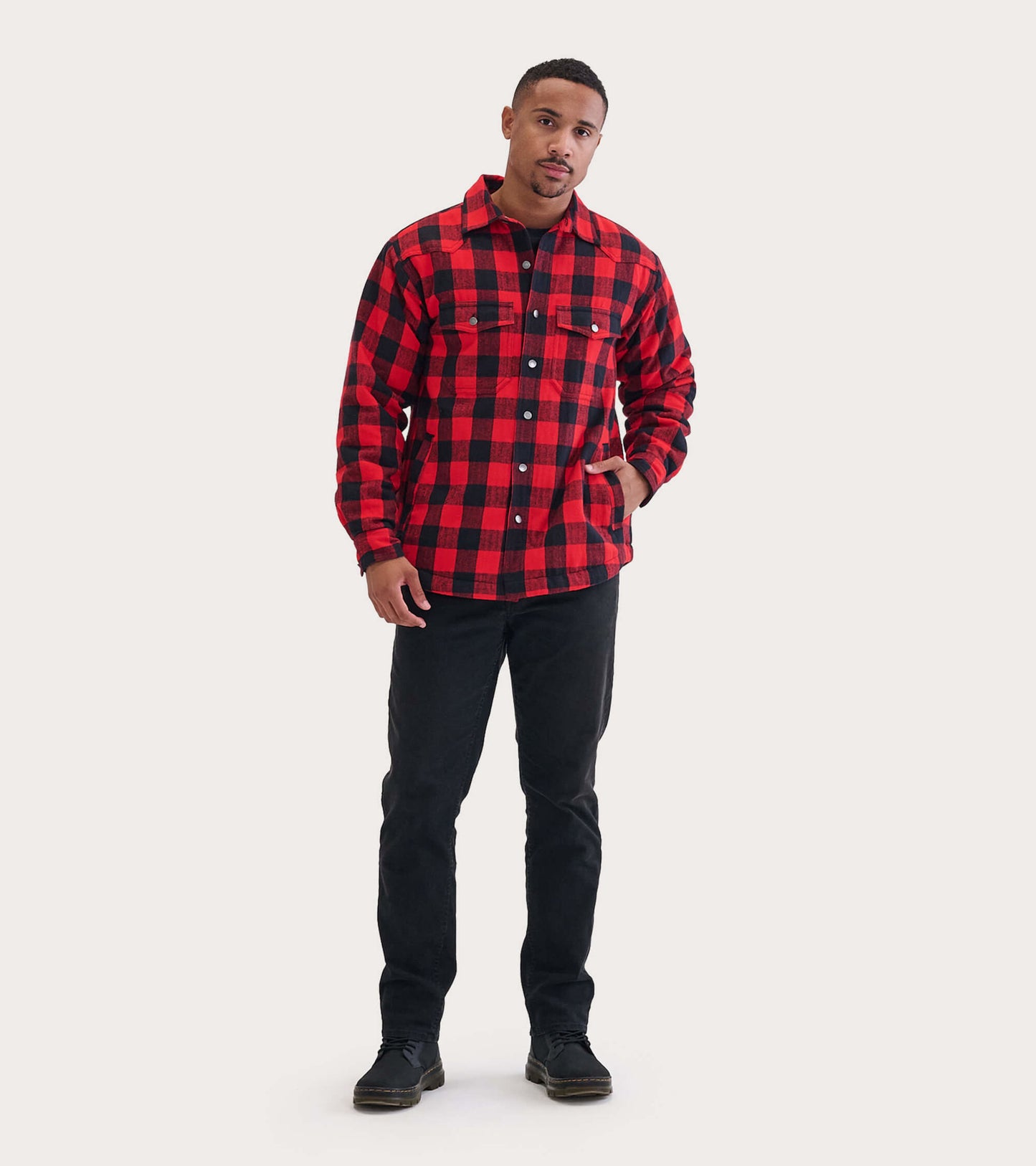 Men's quilted jacket in red and black buffalo plaid, featuring a button-up front and two chest pockets.