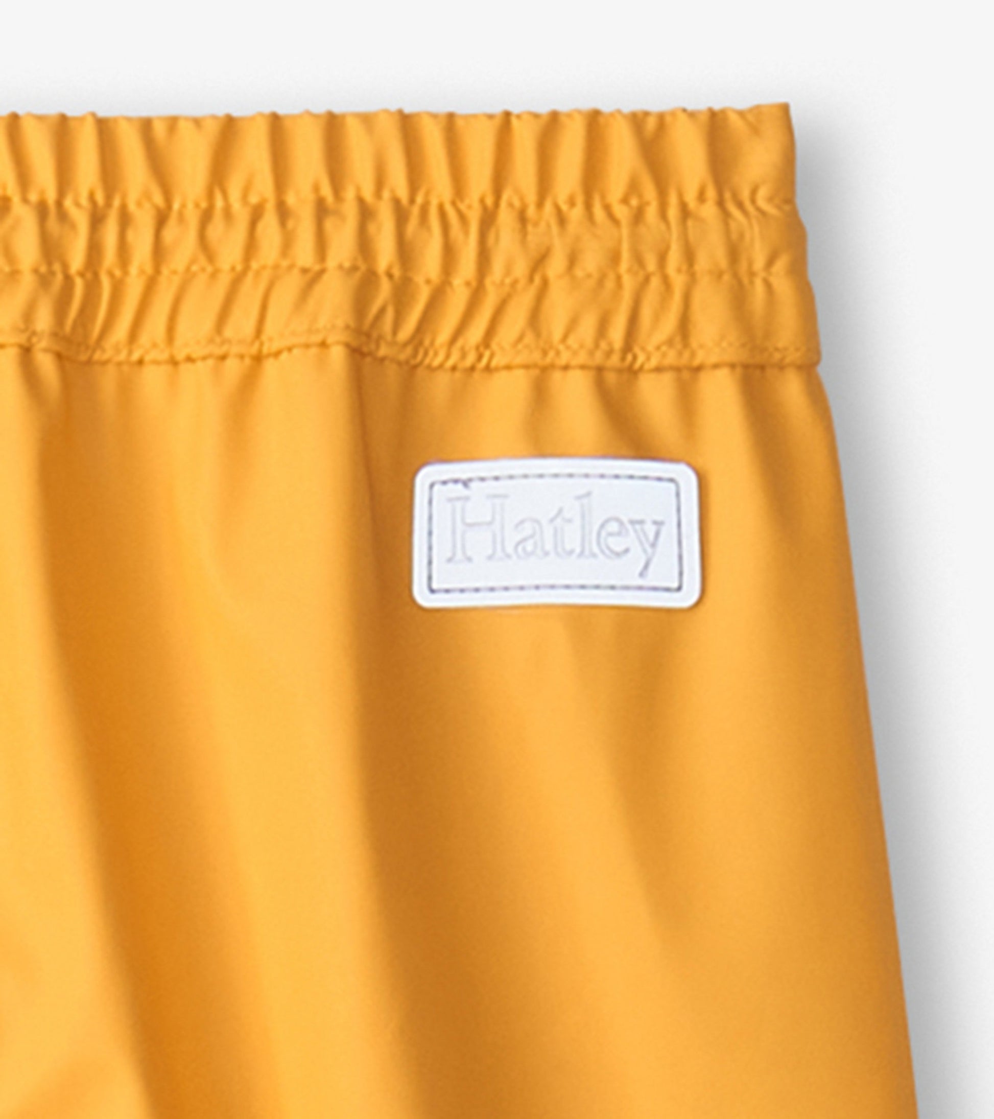 Yellow waterproof kids' rain pants with an elastic waistband for comfort.