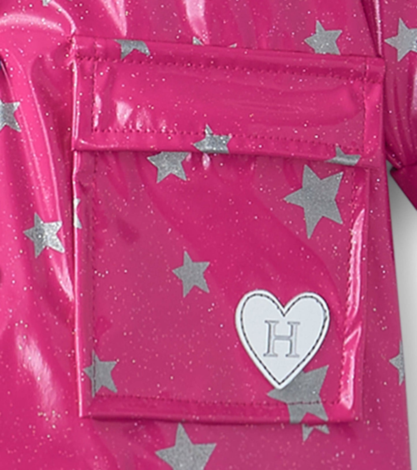 Pink baby raincoat featuring silver glitter stars and a heart-shaped patch with an "H" on the front pocket.