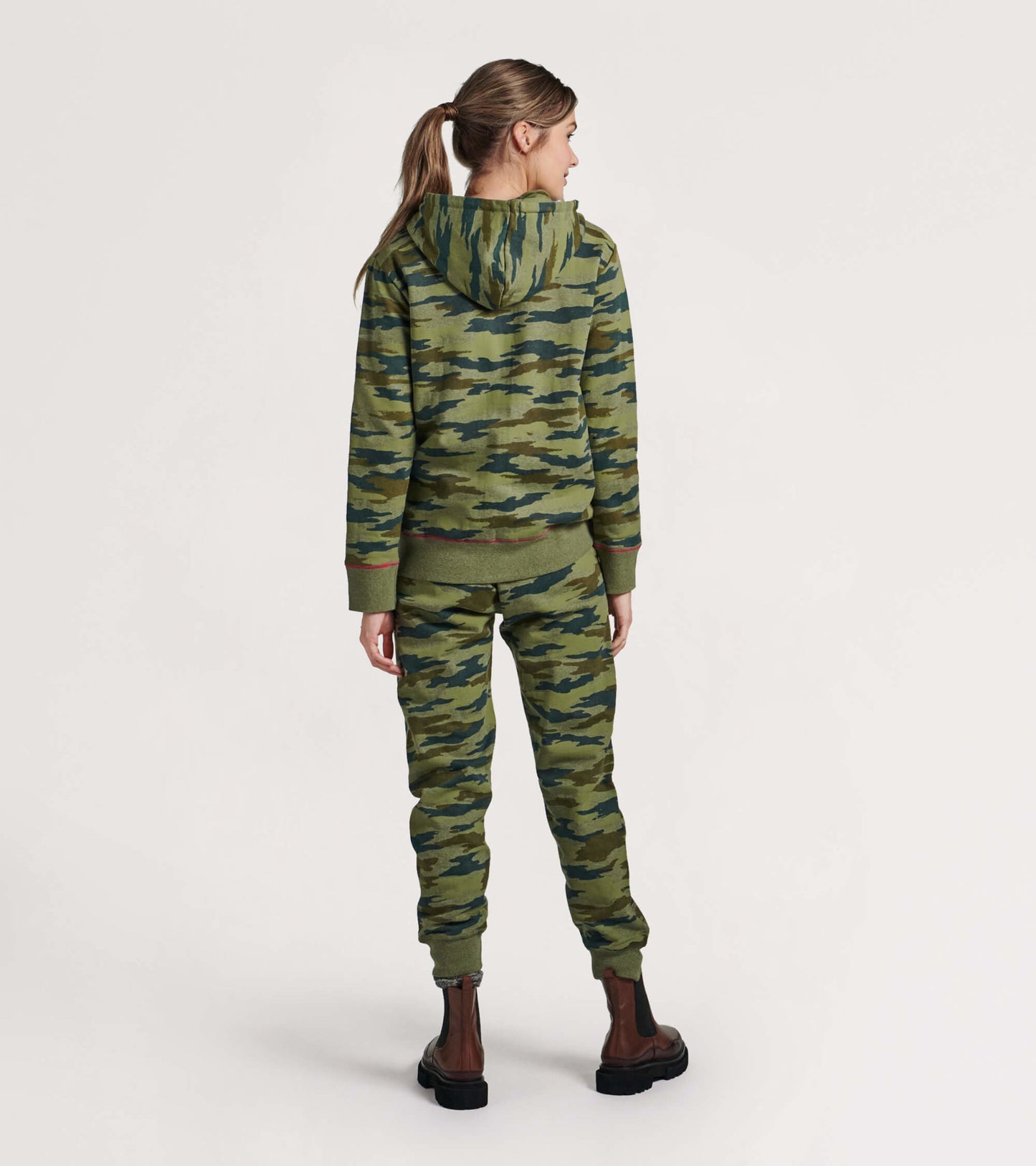 Women's full zip hoodie in woodland camo pattern, featuring a hood and ribbed cuffs, shown from the back.