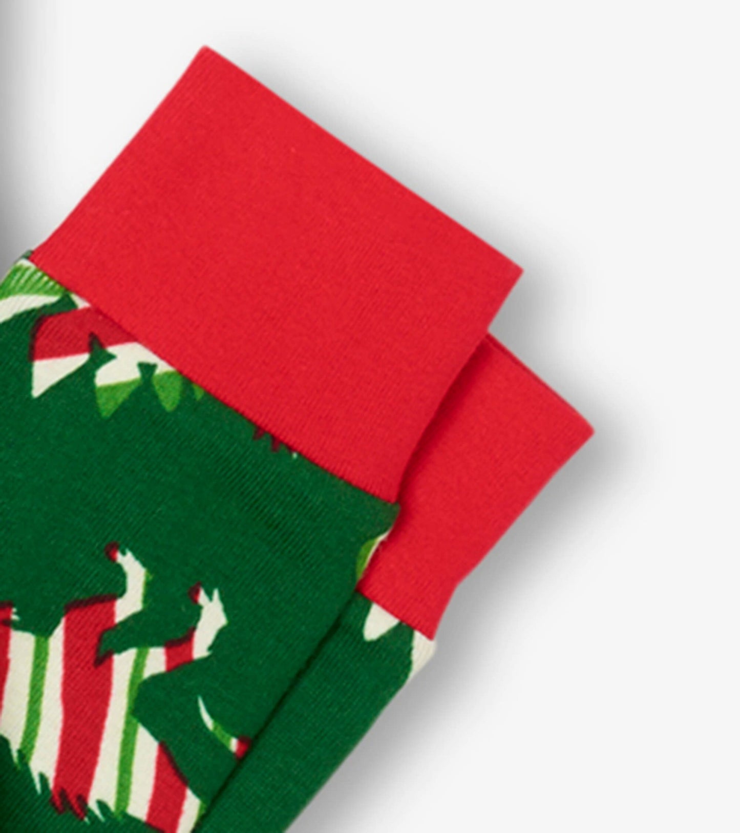 Green pajama fabric featuring festive dinosaurs, with red cuffs and a playful holiday pattern.