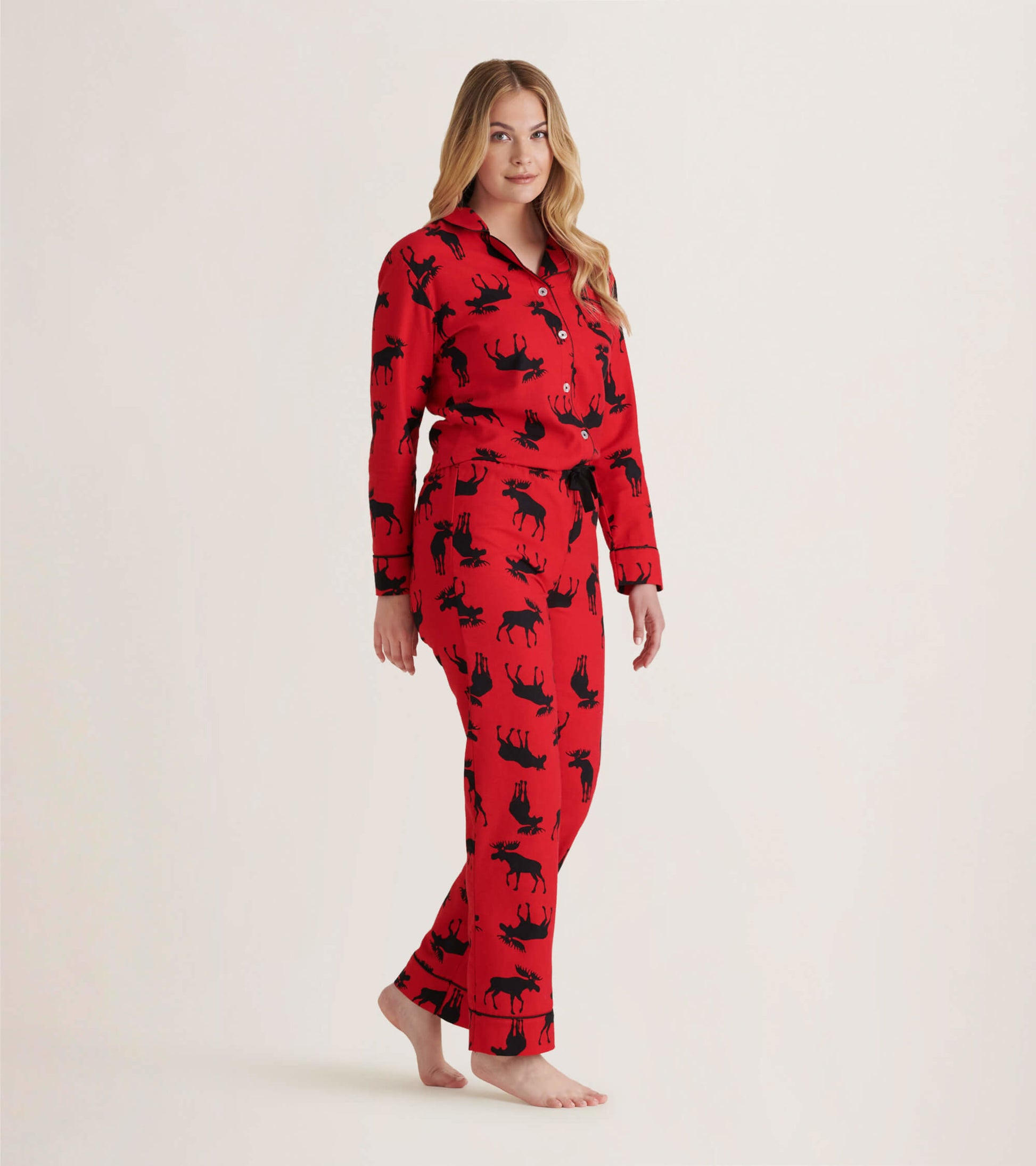 Red flannel pajama set featuring black moose patterns, with a button-up top and matching pants.