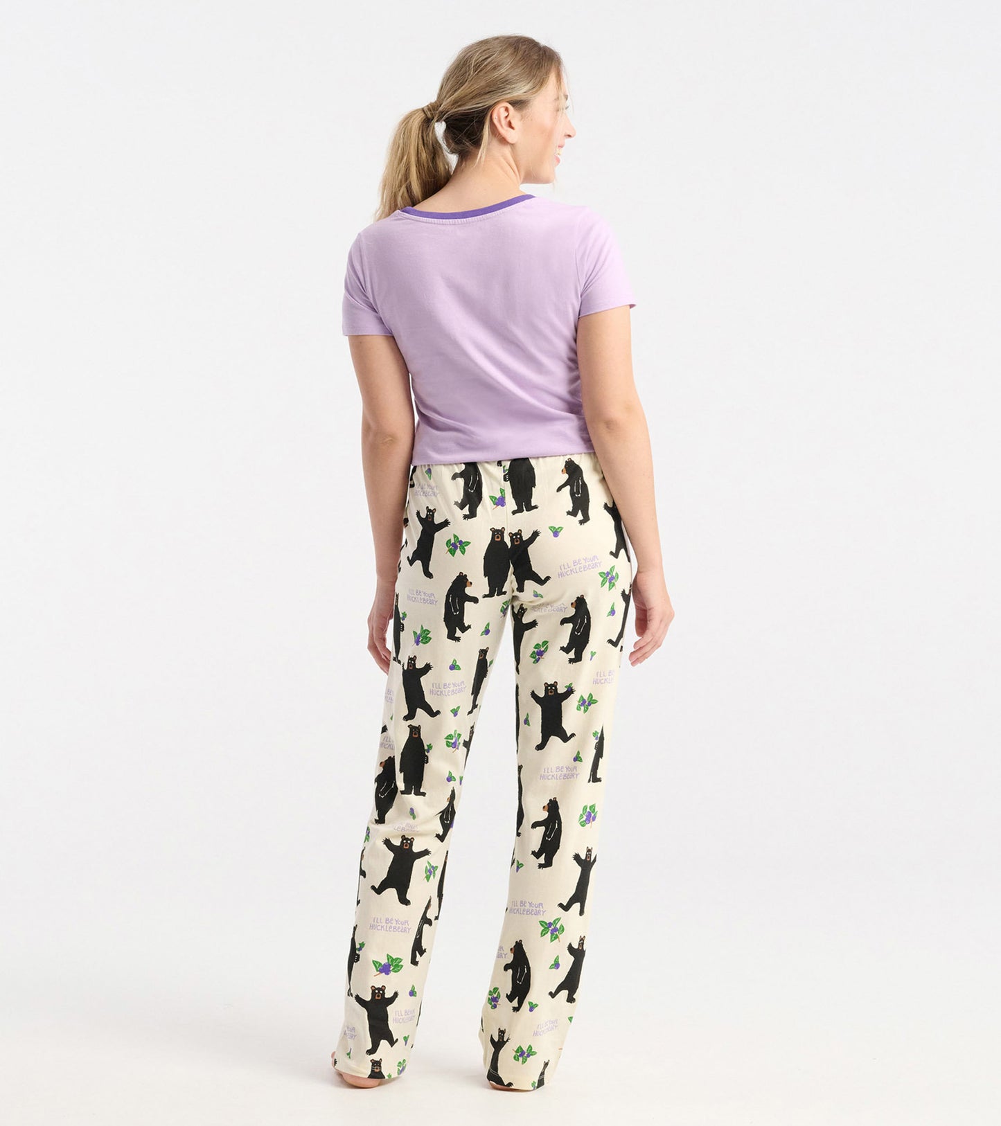 Purple short-sleeve pajama t-shirt paired with cream pants featuring black bears and green accents, viewed from the back.