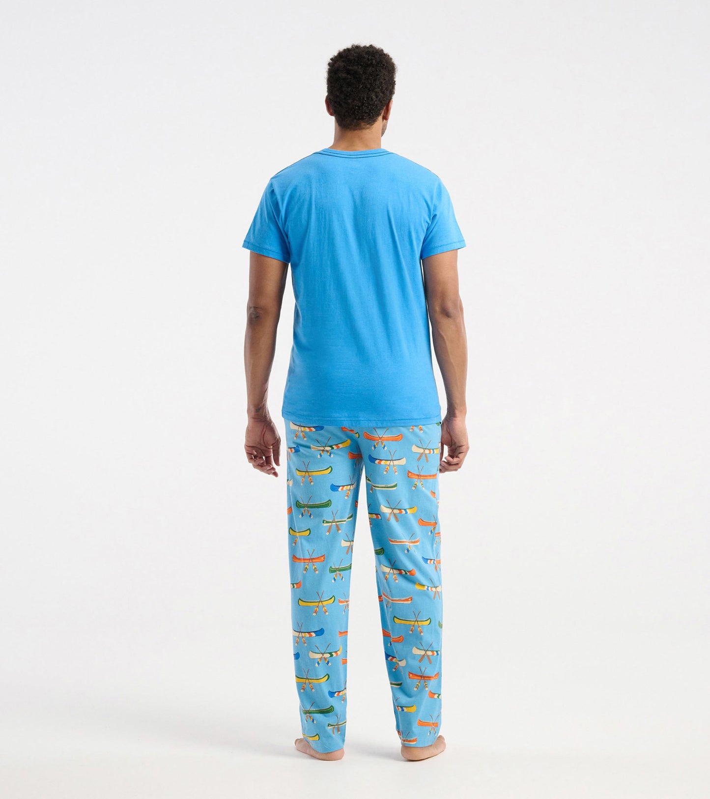 Men's blue short-sleeve tee paired with patterned pajama pants featuring colorful canoes.