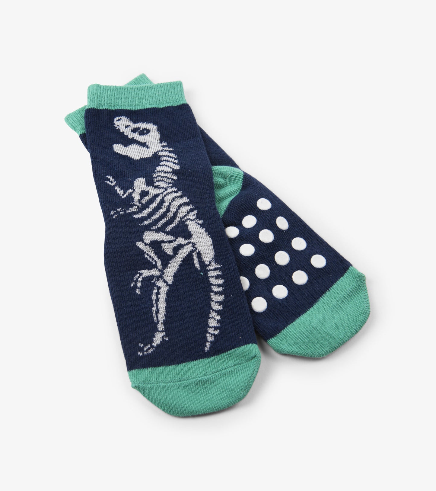 Navy socks featuring a white dinosaur skeleton design and green accents, with non-slip polka dots on the sole.