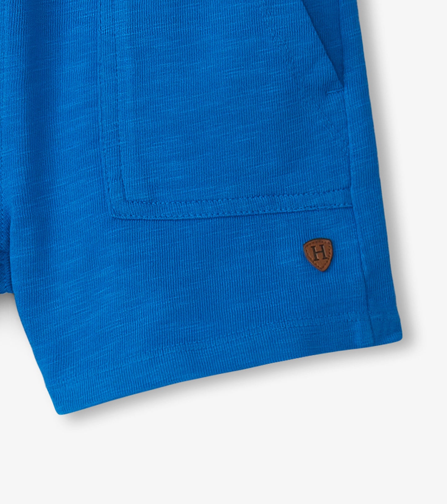 Deep blue relaxed shorts with a textured fabric and side pockets, featuring a small logo patch.