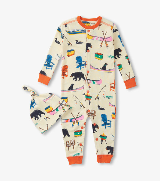 Cream-colored baby sleeper with colorful lake-themed prints and matching hat, featuring orange accents and buttons.