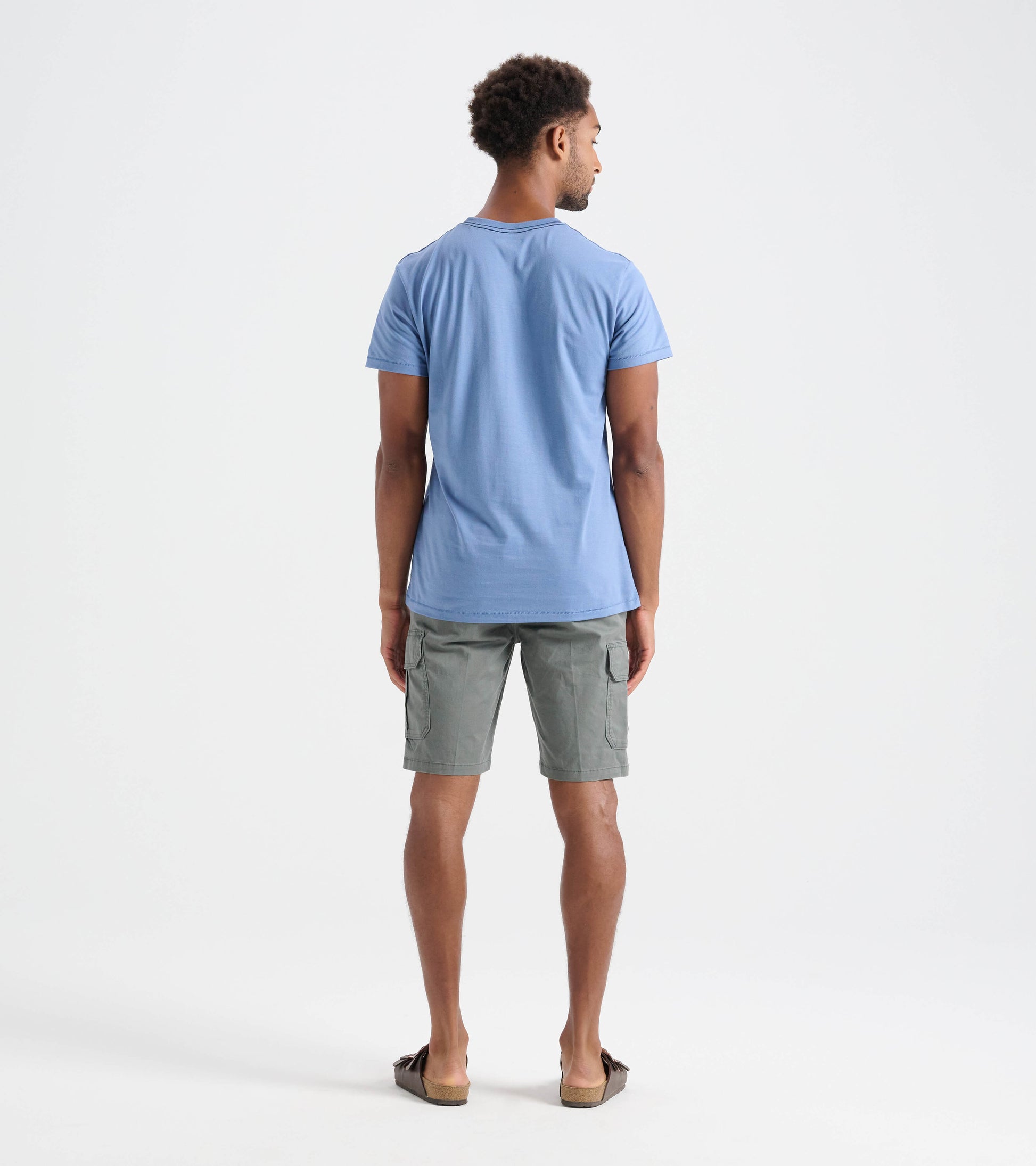 Men's short-sleeve tee in light blue, viewed from the back, paired with gray cargo shorts.