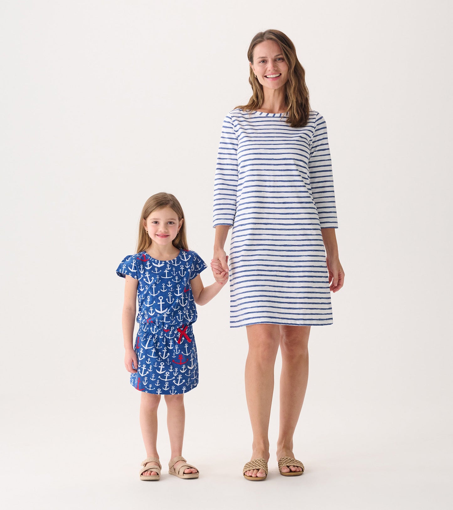 Blue t-shirt dress with anchor pattern for girls, paired with a striped dress for women, both casual and comfortable.