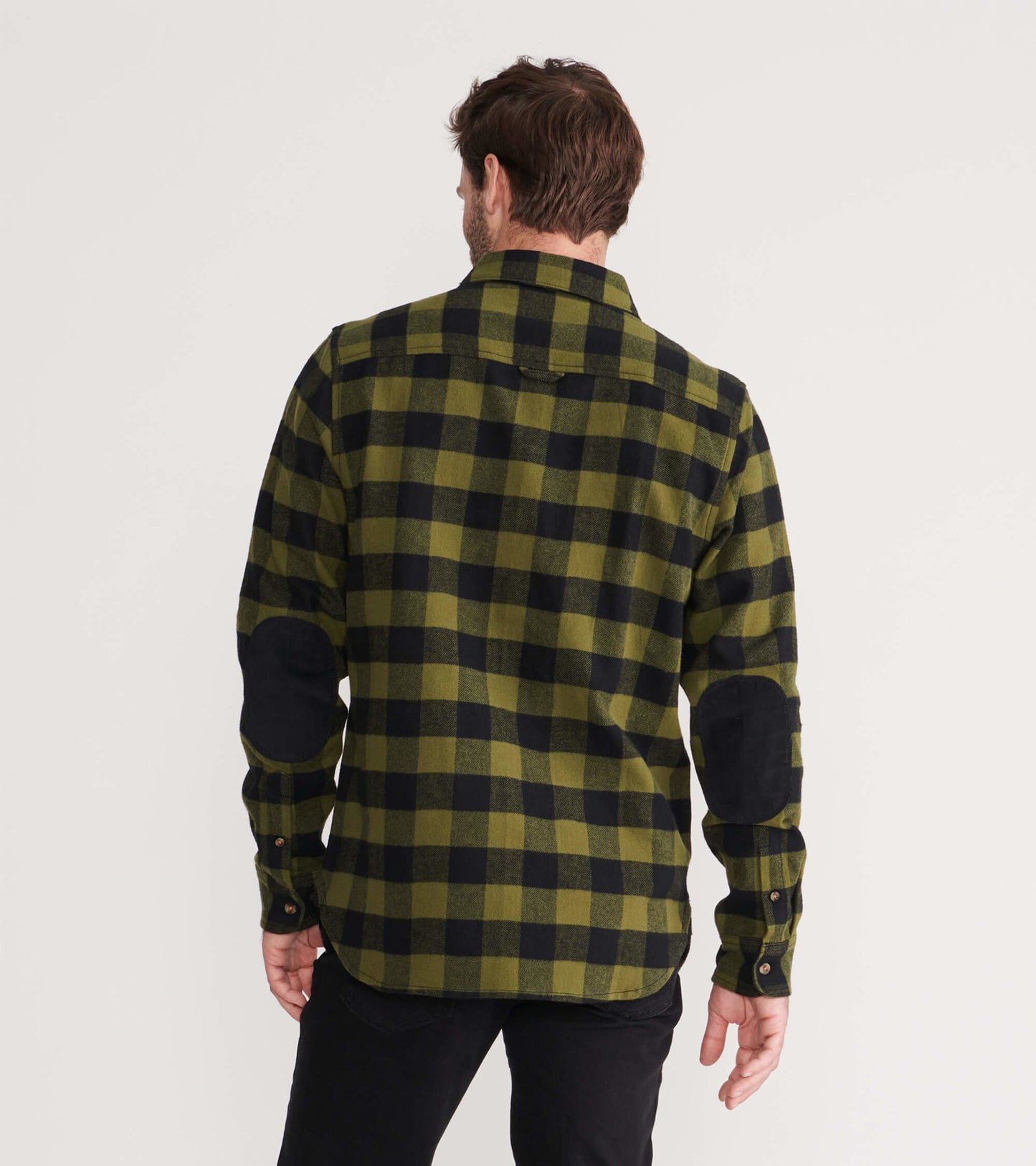 Men's flannel shirt in green and black plaid, featuring elbow patches and a button-down collar, viewed from the back.