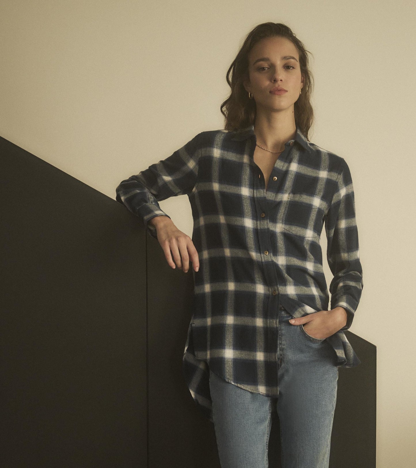 Navy and white plaid tunic with a button-up front and a curved hem, styled with light blue jeans.