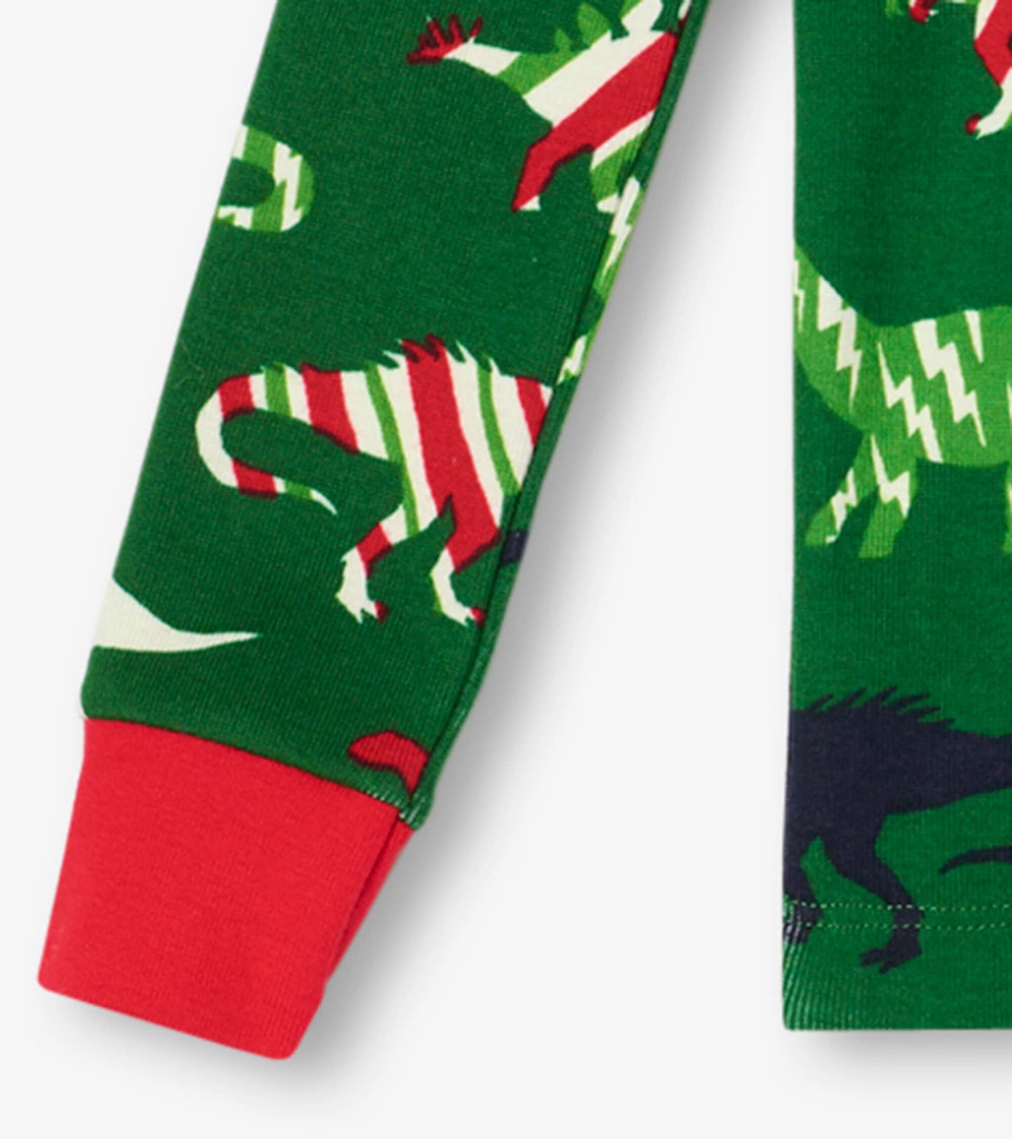Green organic cotton pajama set featuring colorful dinosaur patterns and red cuffs, suitable for kids.