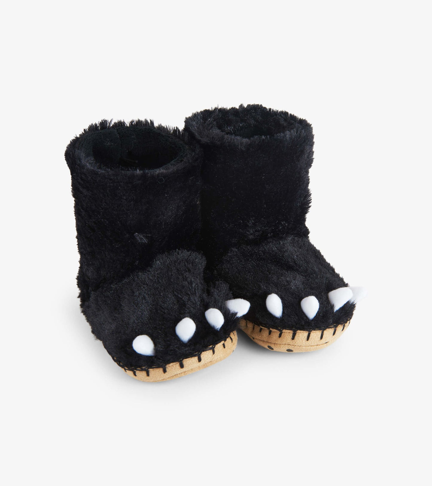 Black fuzzy slouch slippers shaped like bear paws with white claws and a soft interior, suitable for kids.