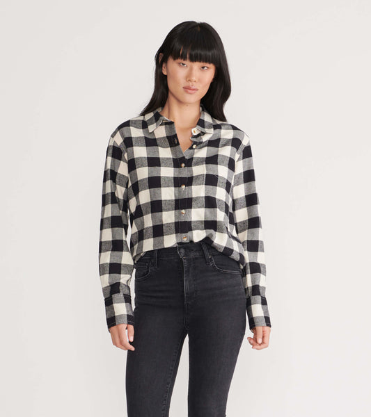 Black and white plaid flannel shirt with a button-up front and long sleeves, styled with high-waisted black jeans.