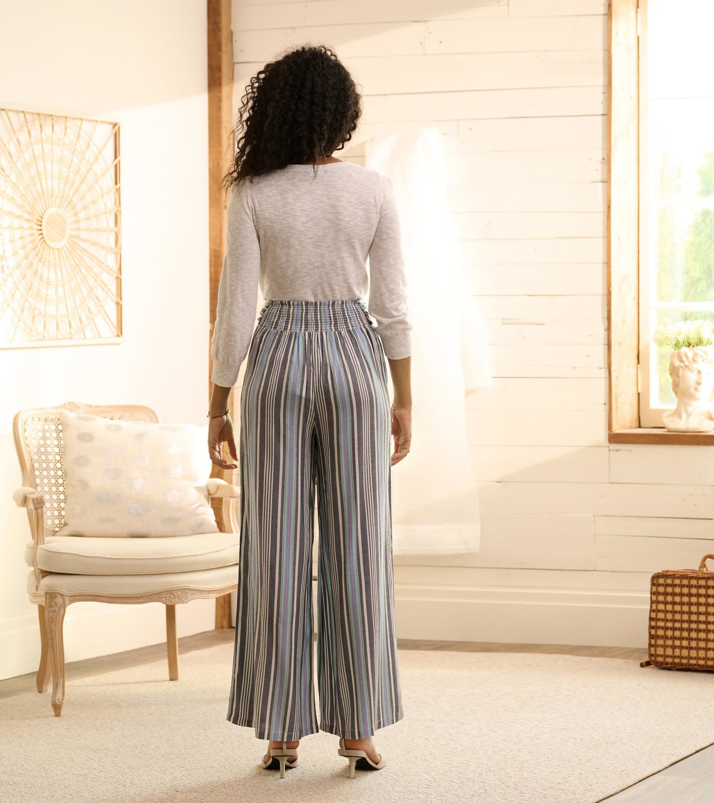 Belted wide leg pants featuring colorful rainbow stripes, shown from the back with a relaxed fit and elastic waistband.