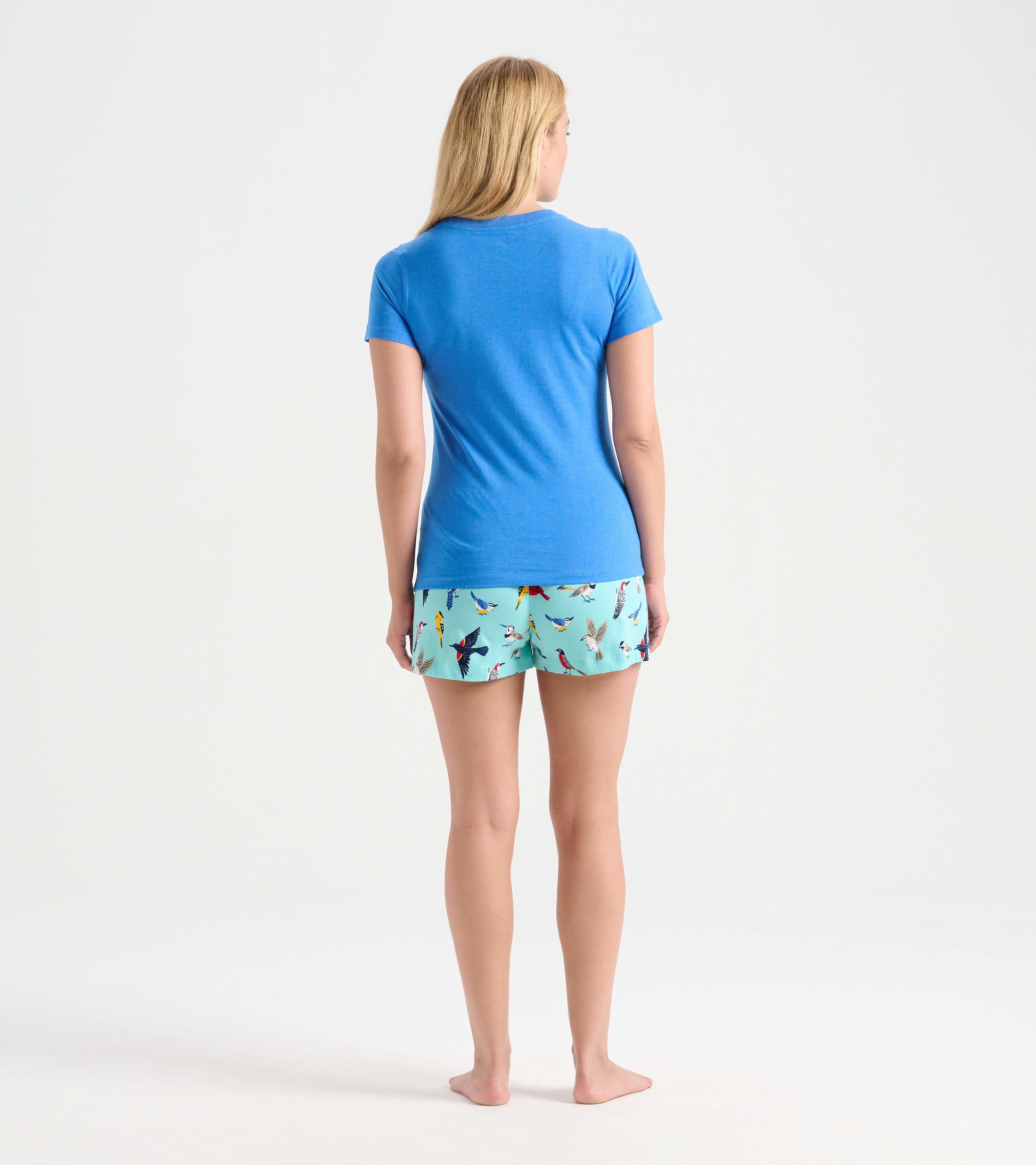 Light blue cotton sleep shorts featuring a colorful bird print, shown from the back with a blue t-shirt.