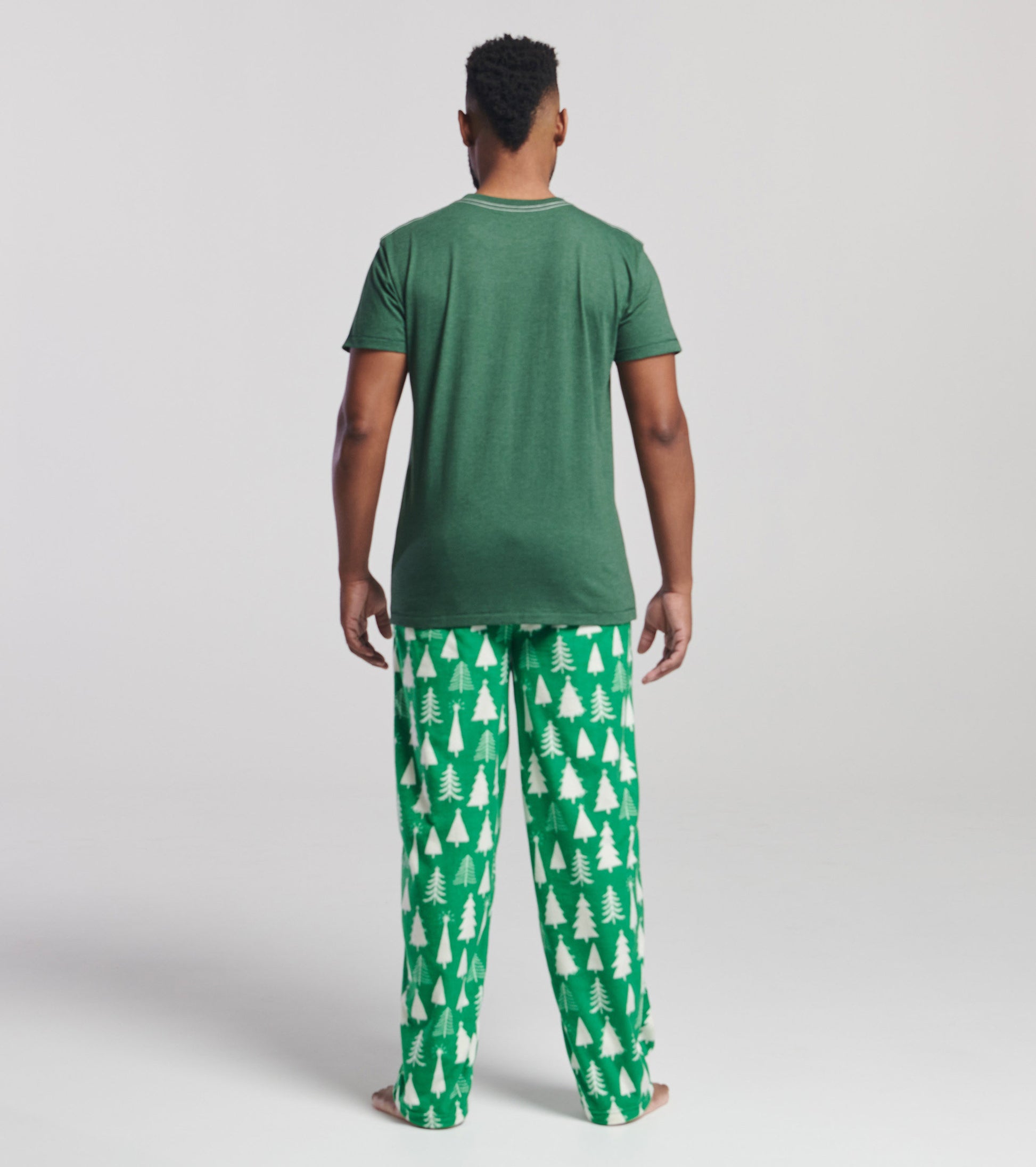 Green short-sleeve t-shirt, viewed from the back, paired with festive green pajama pants featuring white Christmas tree patt…