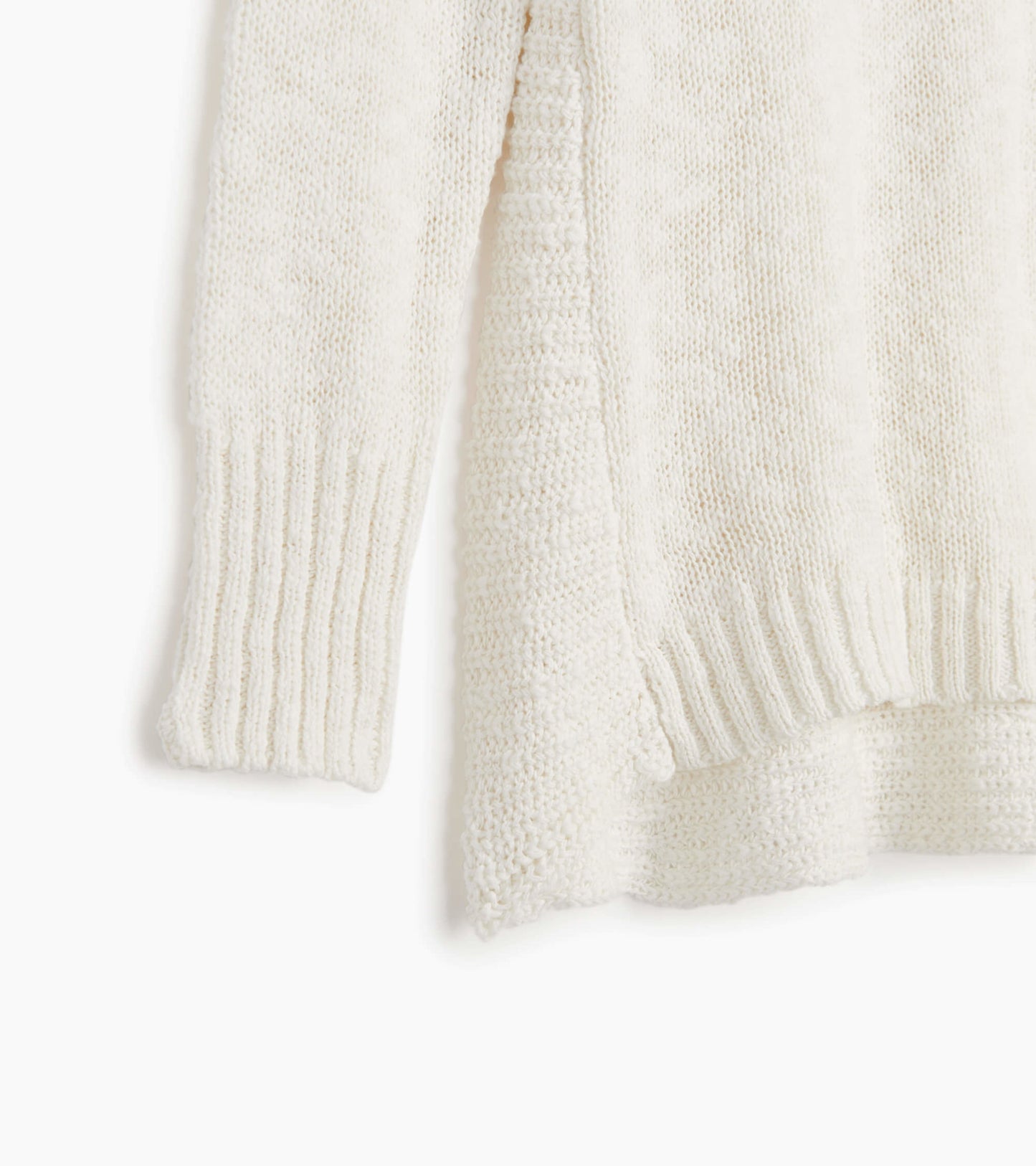 White knitted sweater featuring ribbed cuffs and a relaxed fit. Ideal for layering in cooler weather.