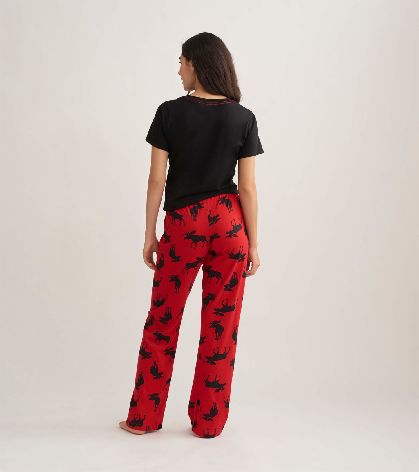 Red cotton pajama pants featuring a moose pattern, shown from the back with a black top.