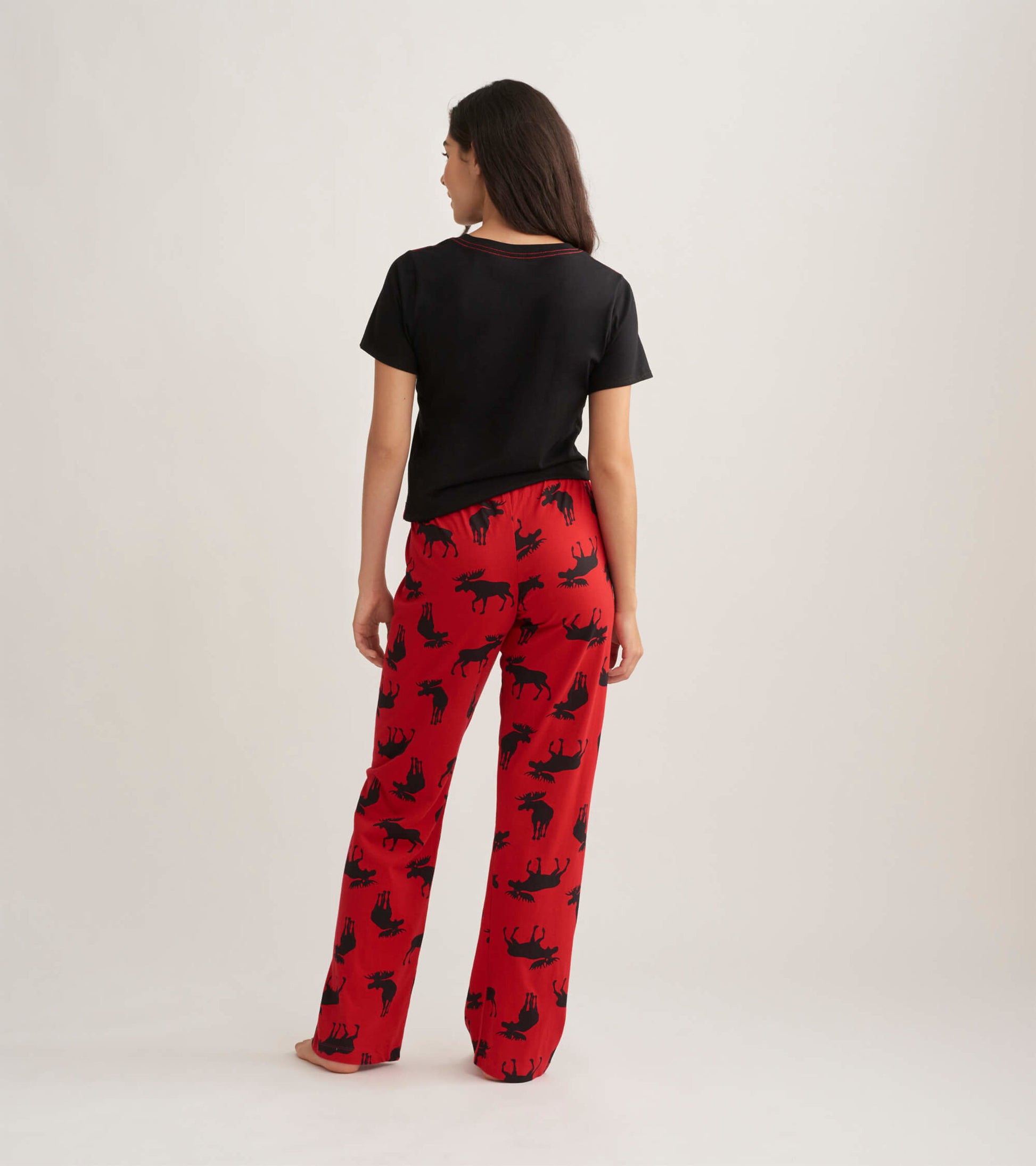 Red cotton pajama pants featuring a moose pattern, shown from the back with a black top.