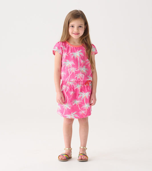 Pink t-shirt dress featuring a palm tree pattern, short sleeves, and an elastic waist, suitable for casual wear.