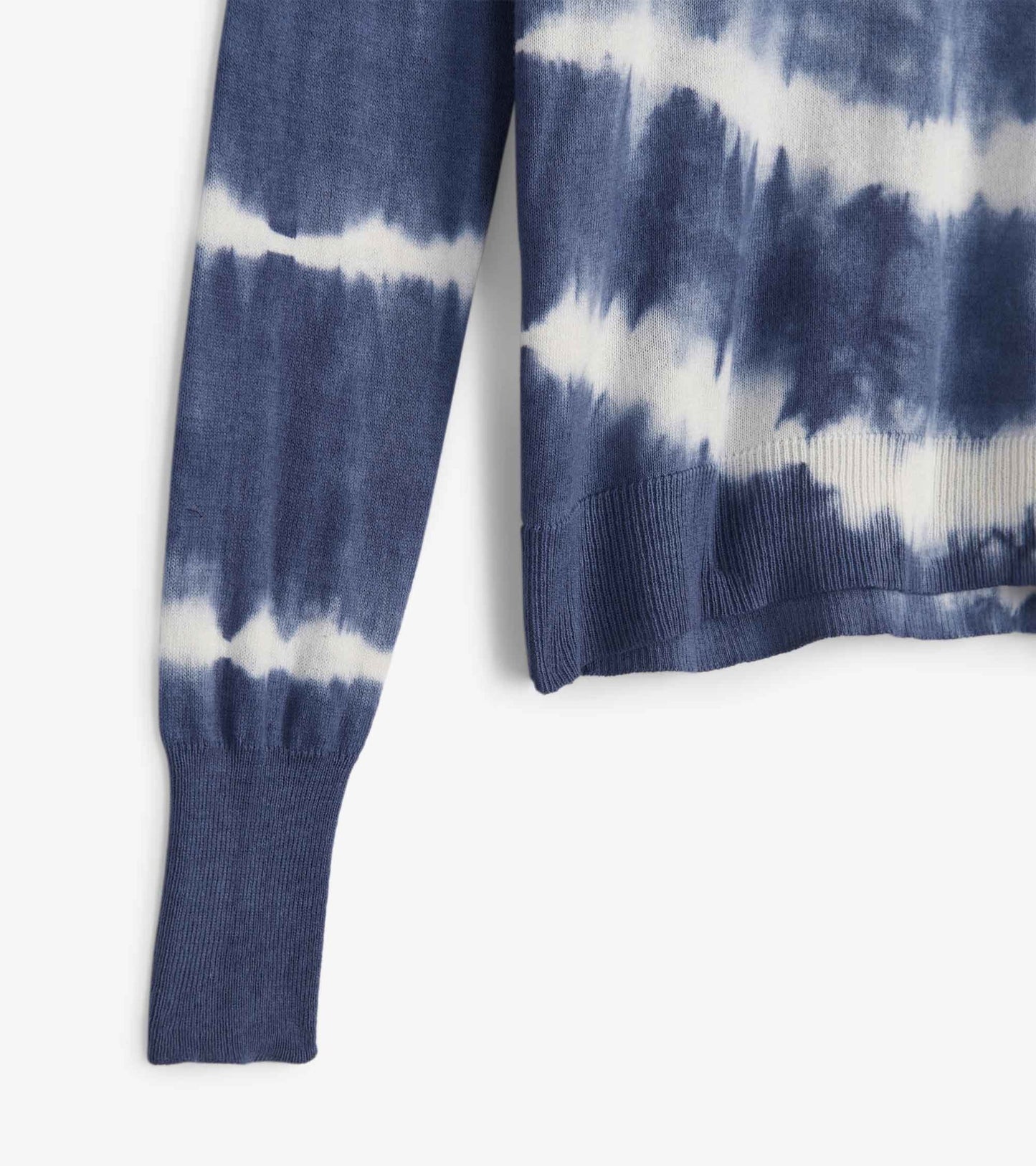 Blue and white tie-dye sweater with ribbed cuffs and hem, showcasing a relaxed fit and soft knit texture.