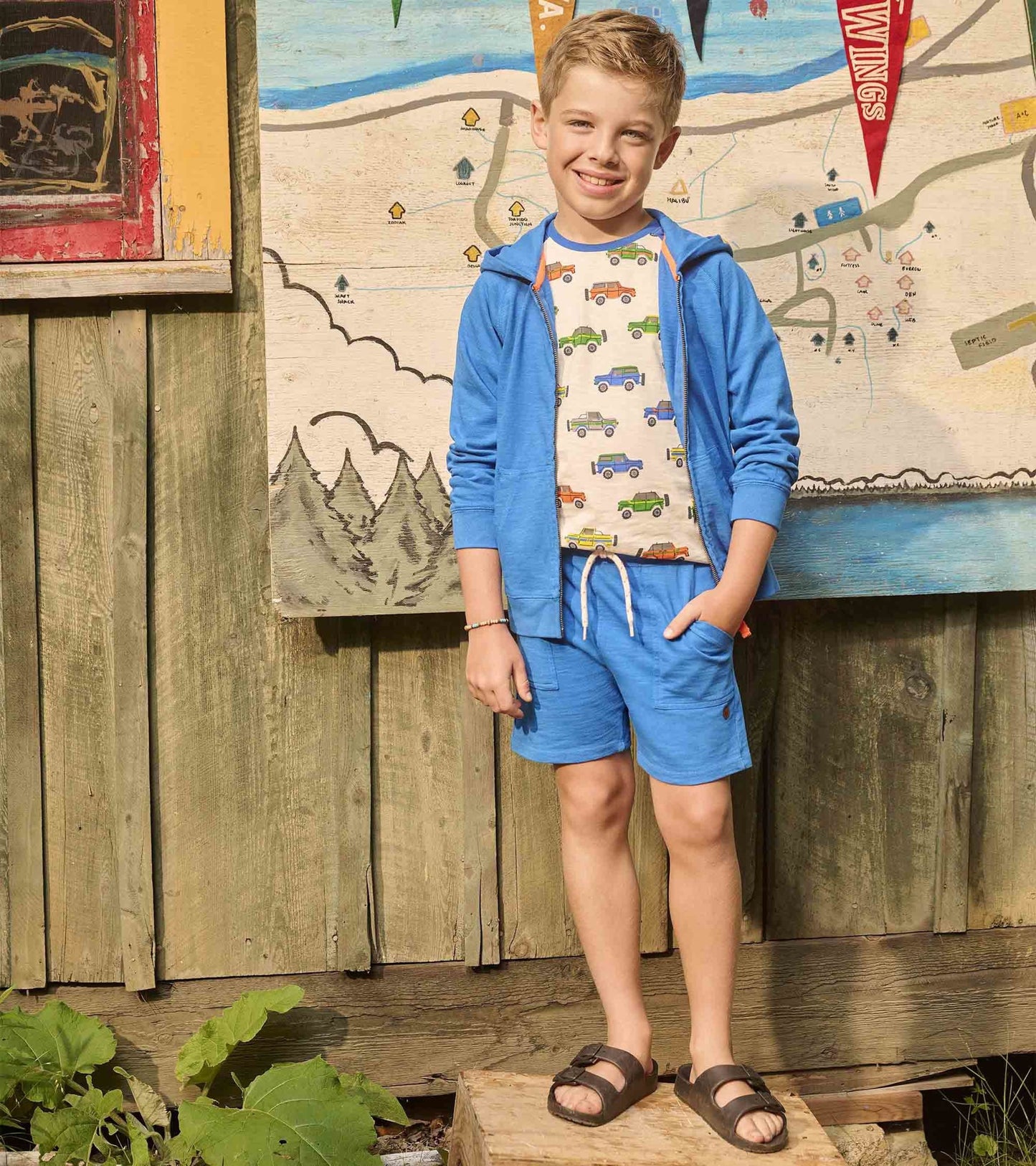 Deep blue relaxed shorts with an elastic waistband and pockets, paired with a colorful truck-patterned shirt.
