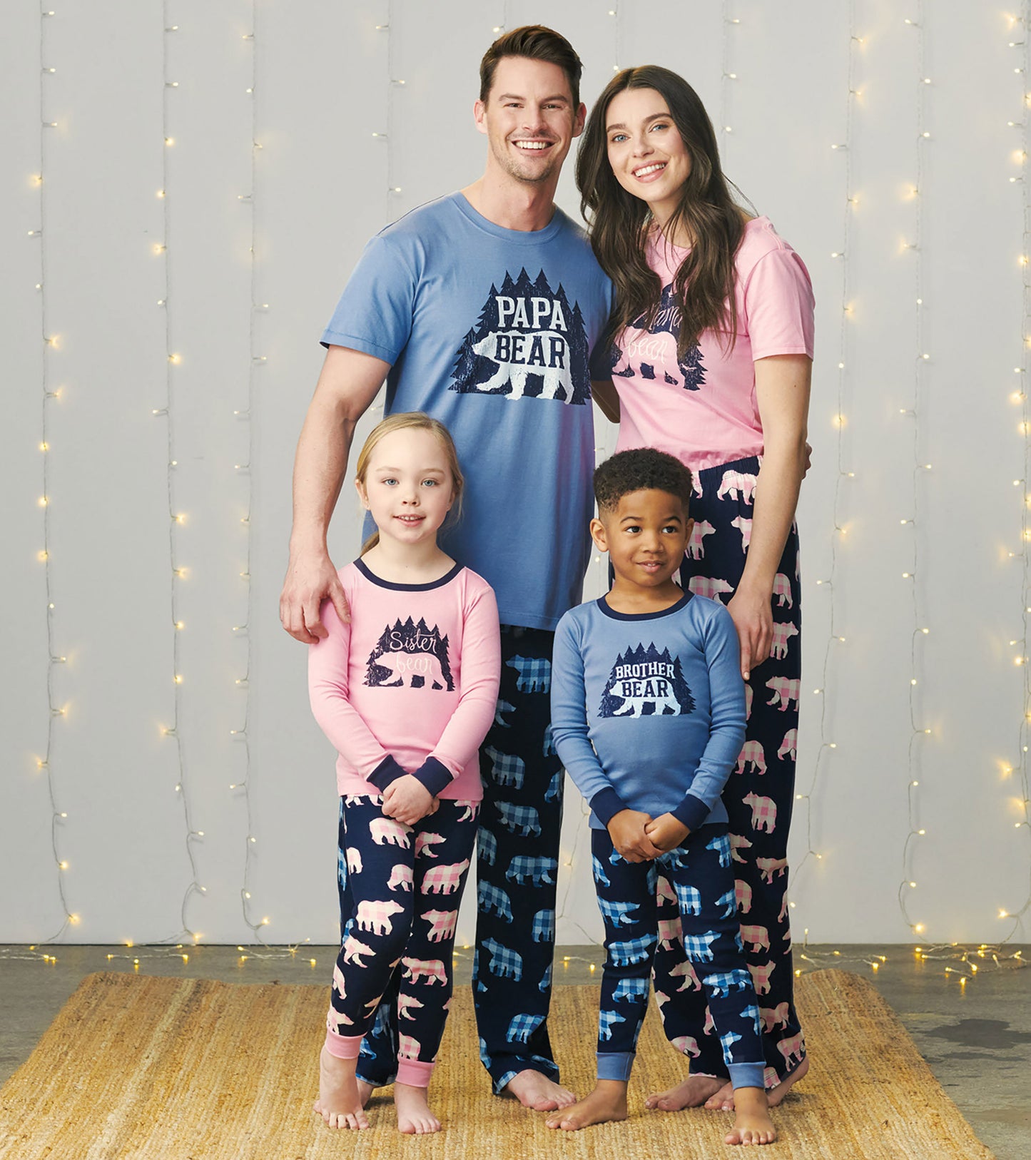 Kids' pajama set featuring pink and blue tops with bear graphics and matching patterned pants in navy.