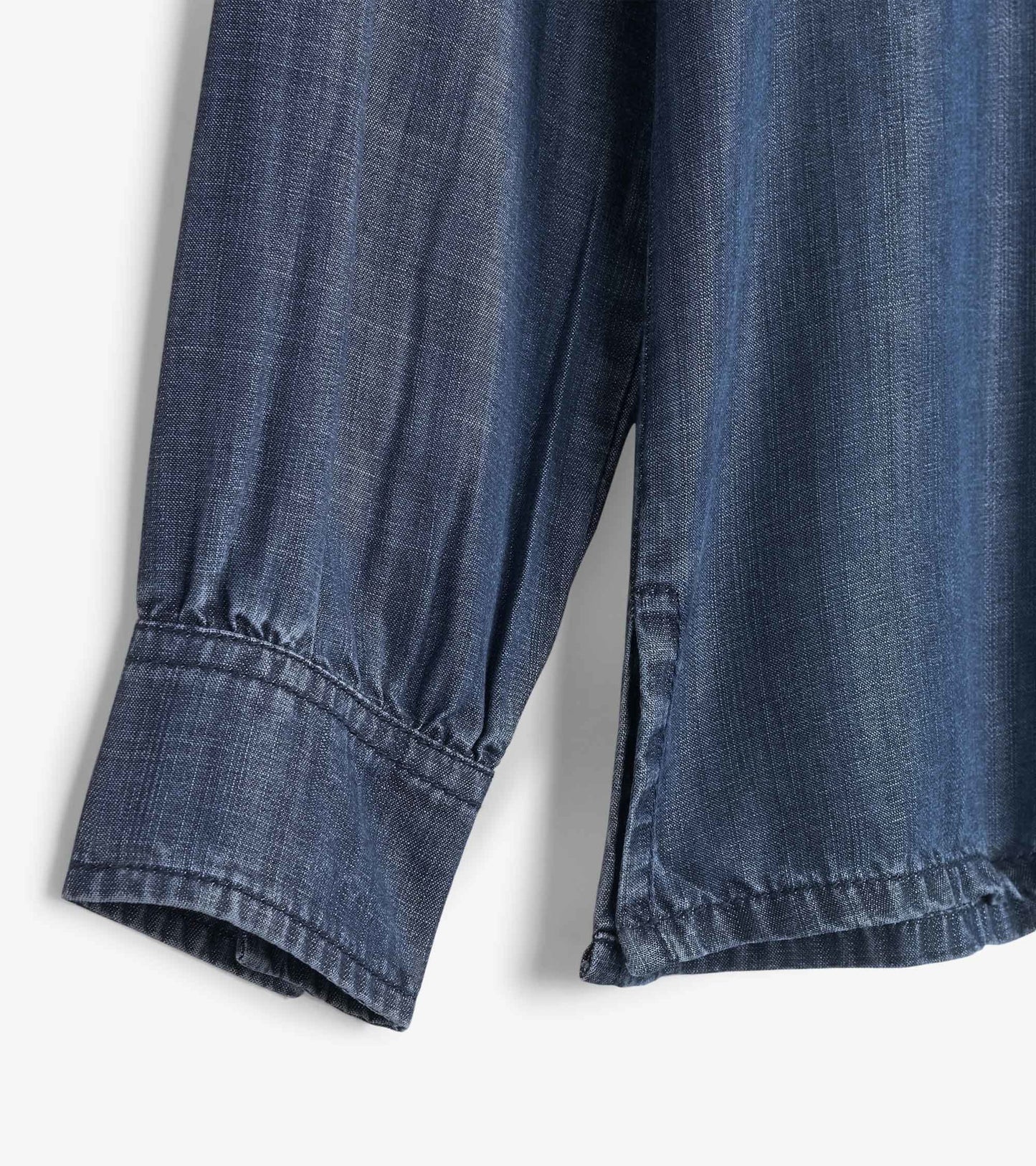 Dark denim button-down shirt with long sleeves and gathered cuffs, showcasing a soft, textured fabric.