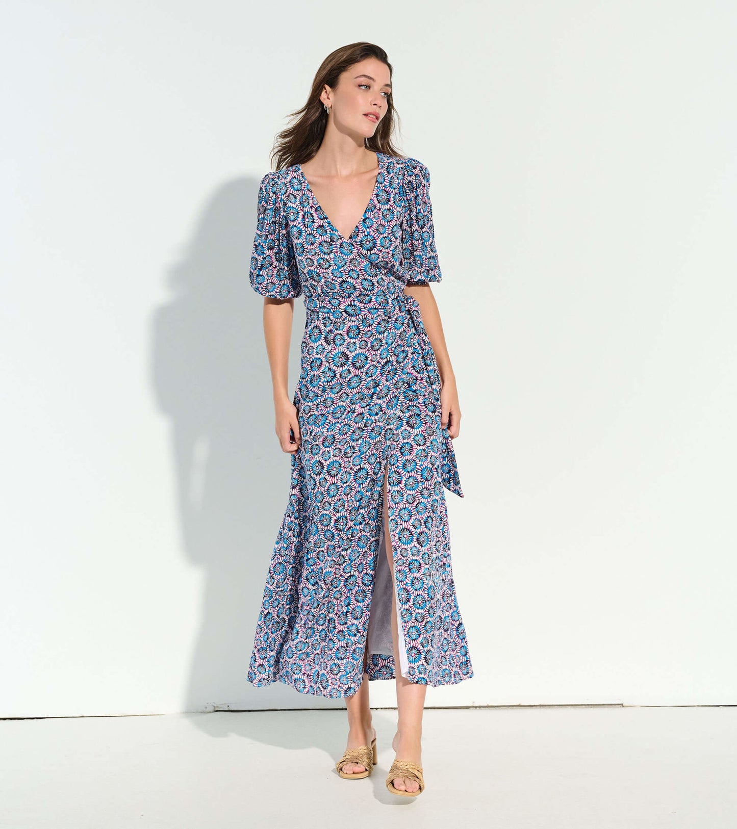 Blue floral wrap dress with puff sleeves and a side slit, perfect for casual or semi-formal occasions.