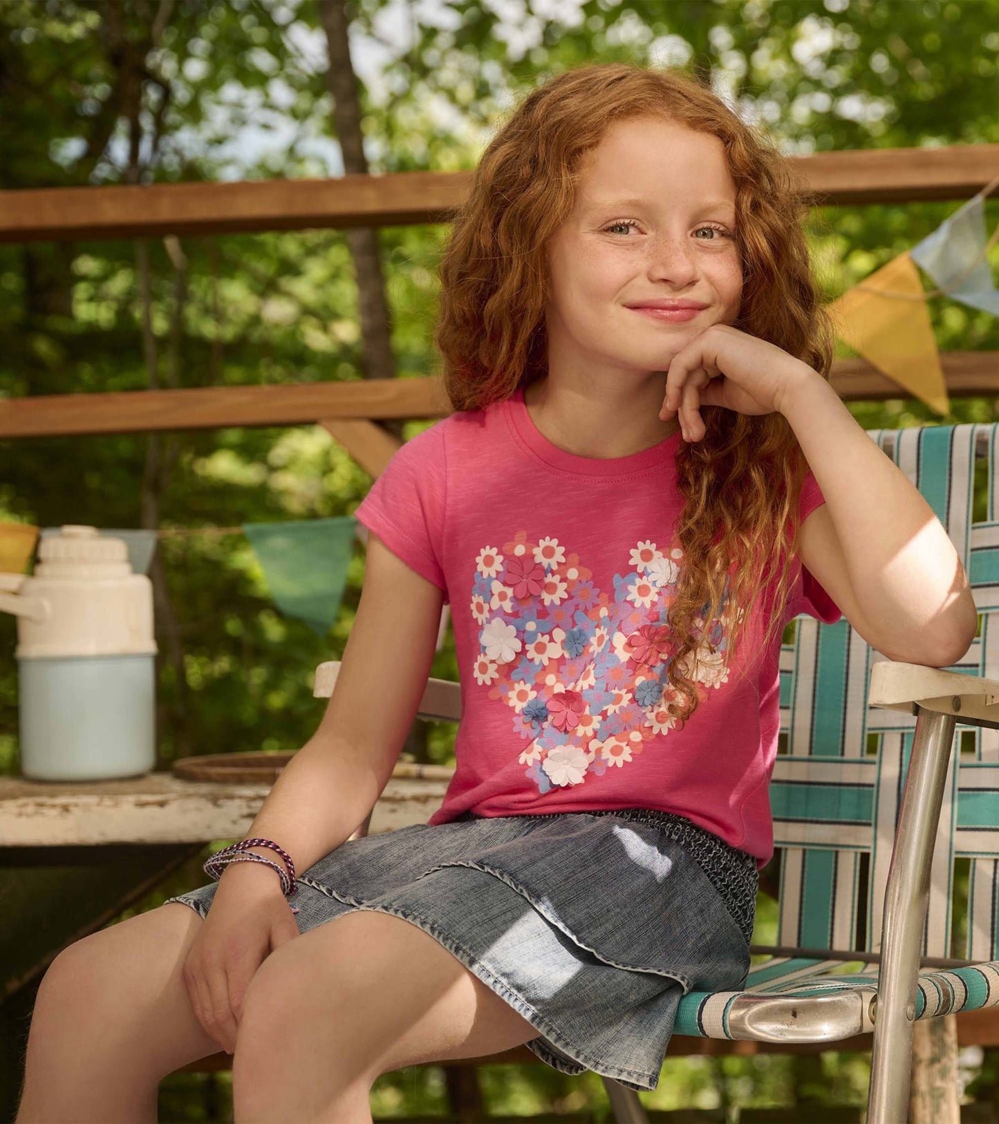 Pink chiffon t-shirt with a heart-shaped floral print, short sleeves, paired with a denim skirt.