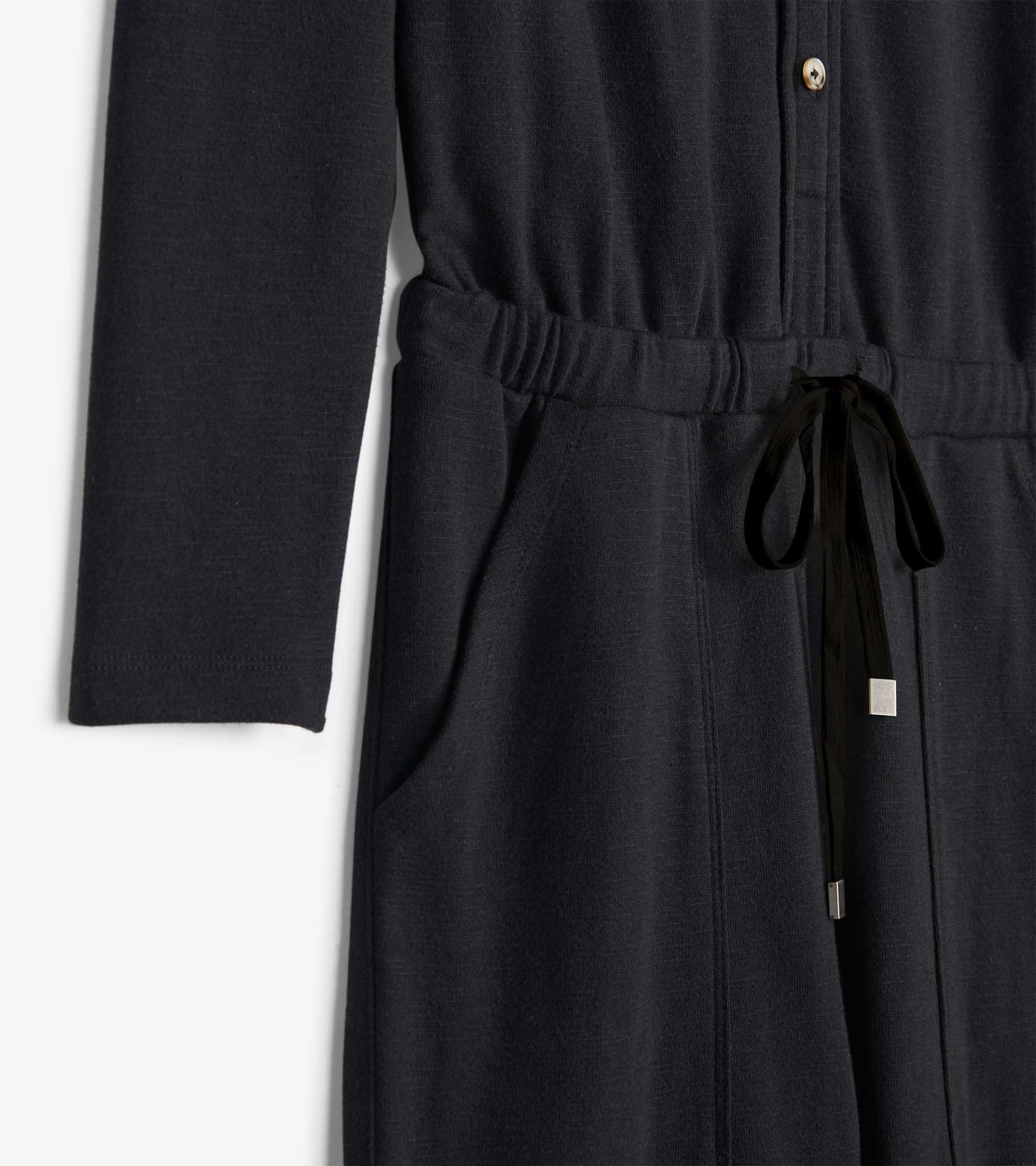 Black jumpsuit with long sleeves, button front, elastic waist, and drawstring detail, featuring side pockets.