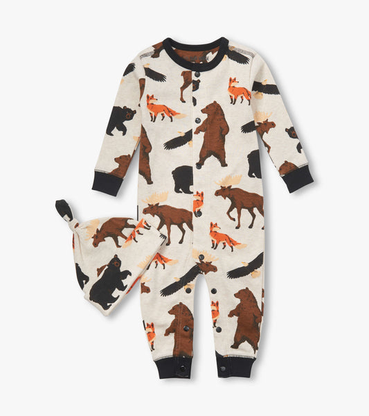 Cream-colored baby sleeper with wildlife patterns, featuring bears, moose, and foxes, paired with a matching hat.